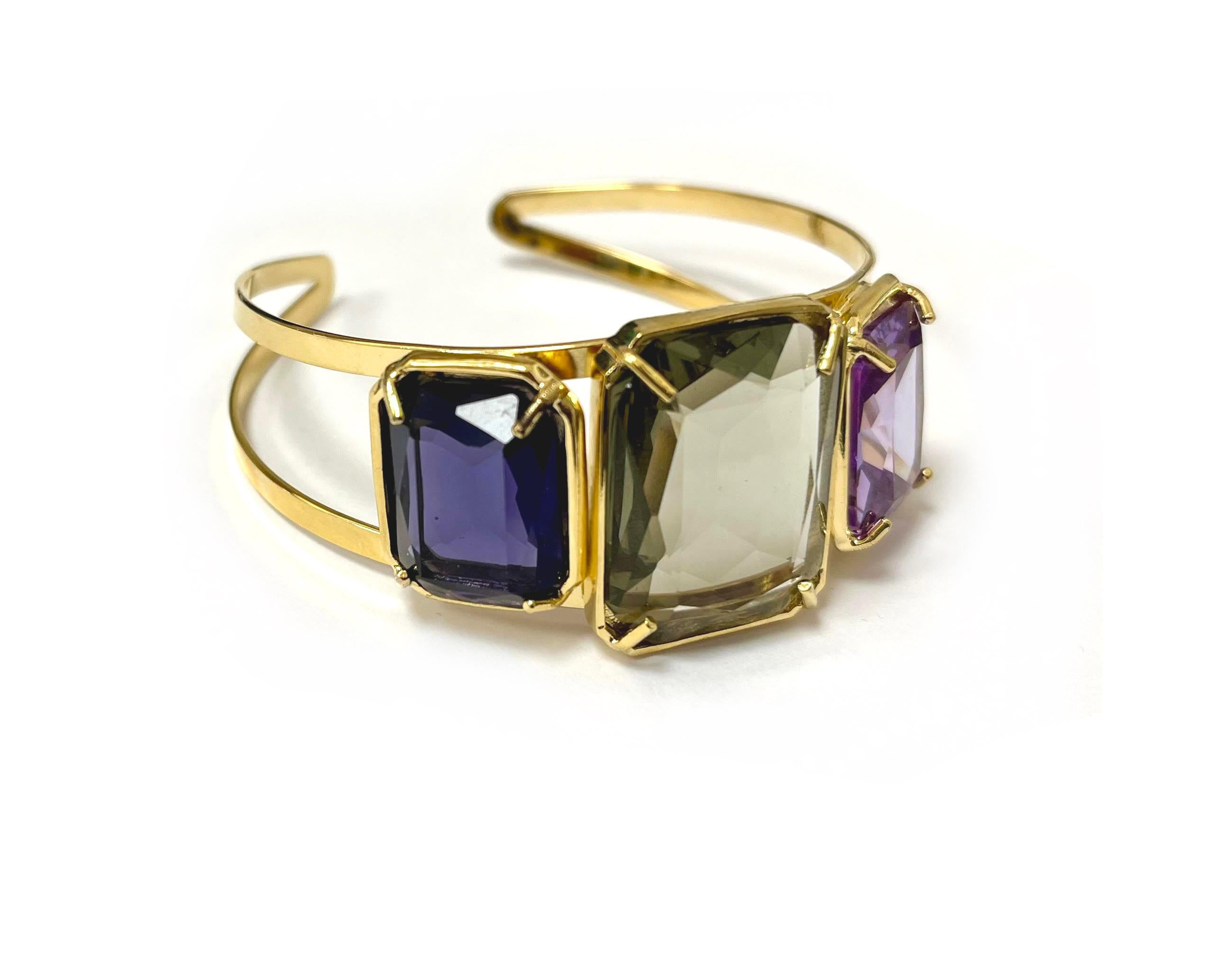 Patrizia Daliana Rigid bracelet in 24 kt gold-plated bronze with smoky gray, amethyst and lilac zirconia. To fix the stones to our jewels, according to the Italian goldsmith tradition, we use the technique of setting with prongs, thus giving the