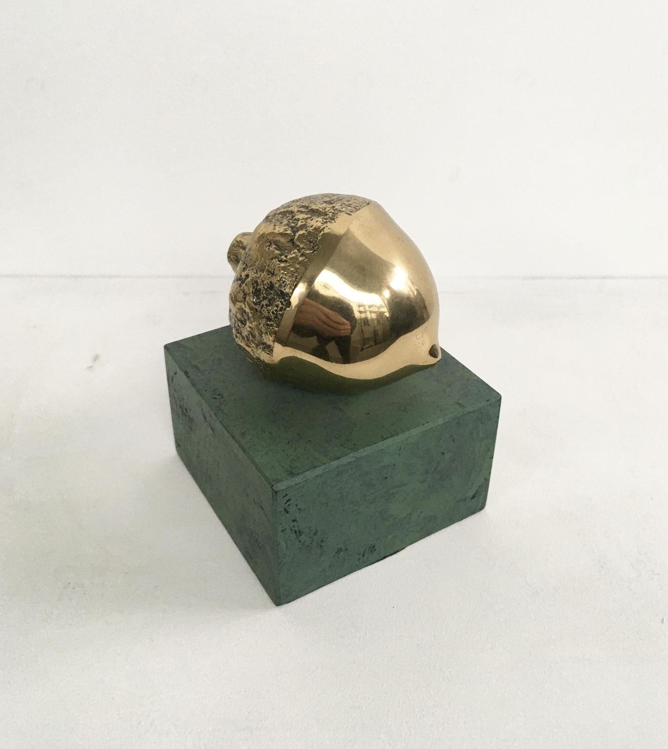 This is an engaging bronze sculpture created by the Italian artist Patrizia Guerresi, in 1986. The piece is a multiple of 1000 specimens on a green-painted wooden base. This artwork is a lucky charm Title 