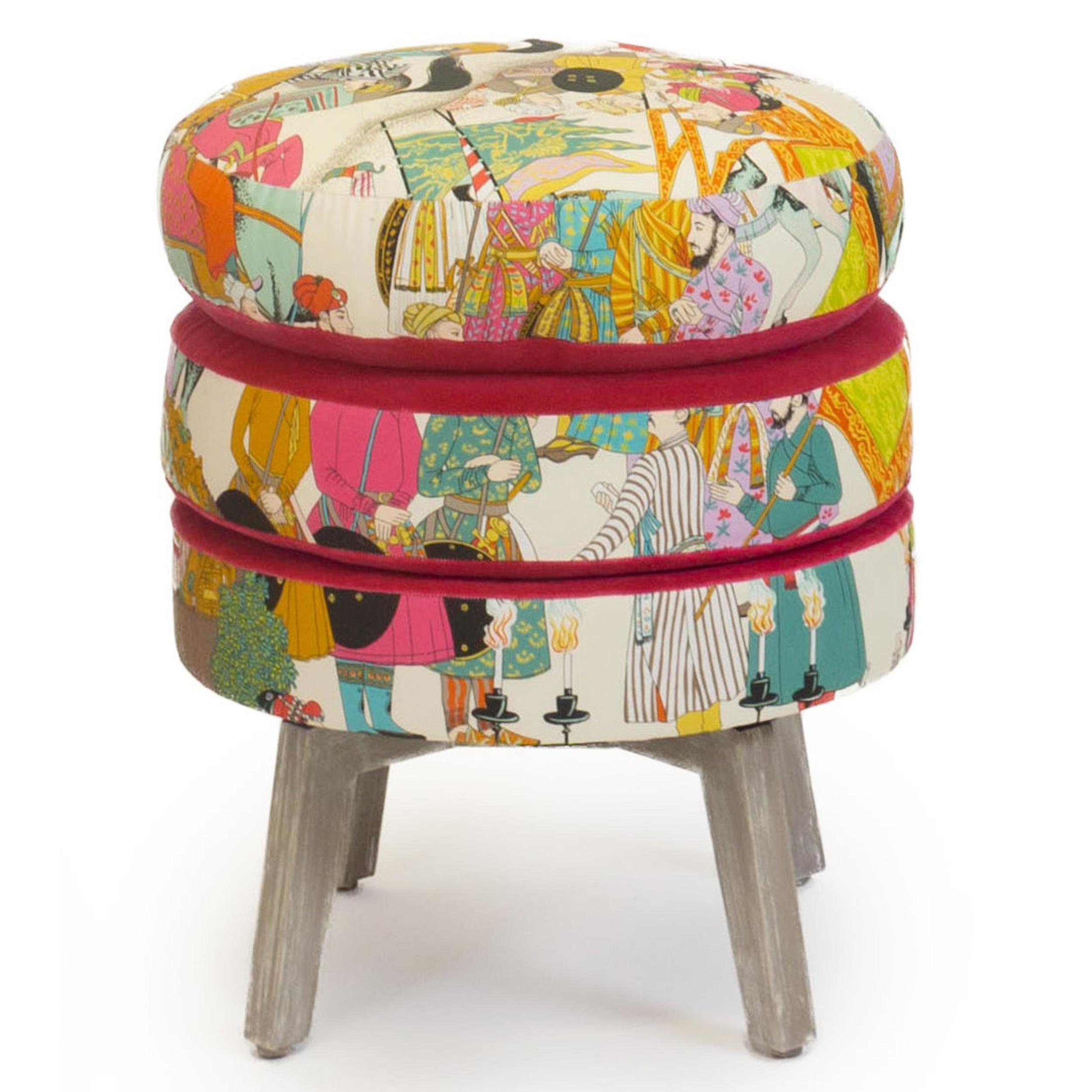 Notre tabouret ottoman à trois couches présente trois couches de coussins en mousse souple recouverts d'un tissu en toile exotique de Manuel Canovas avec un contour en velours rose. Les pieds sont en bois d'érable avec une finition peinte brossée à