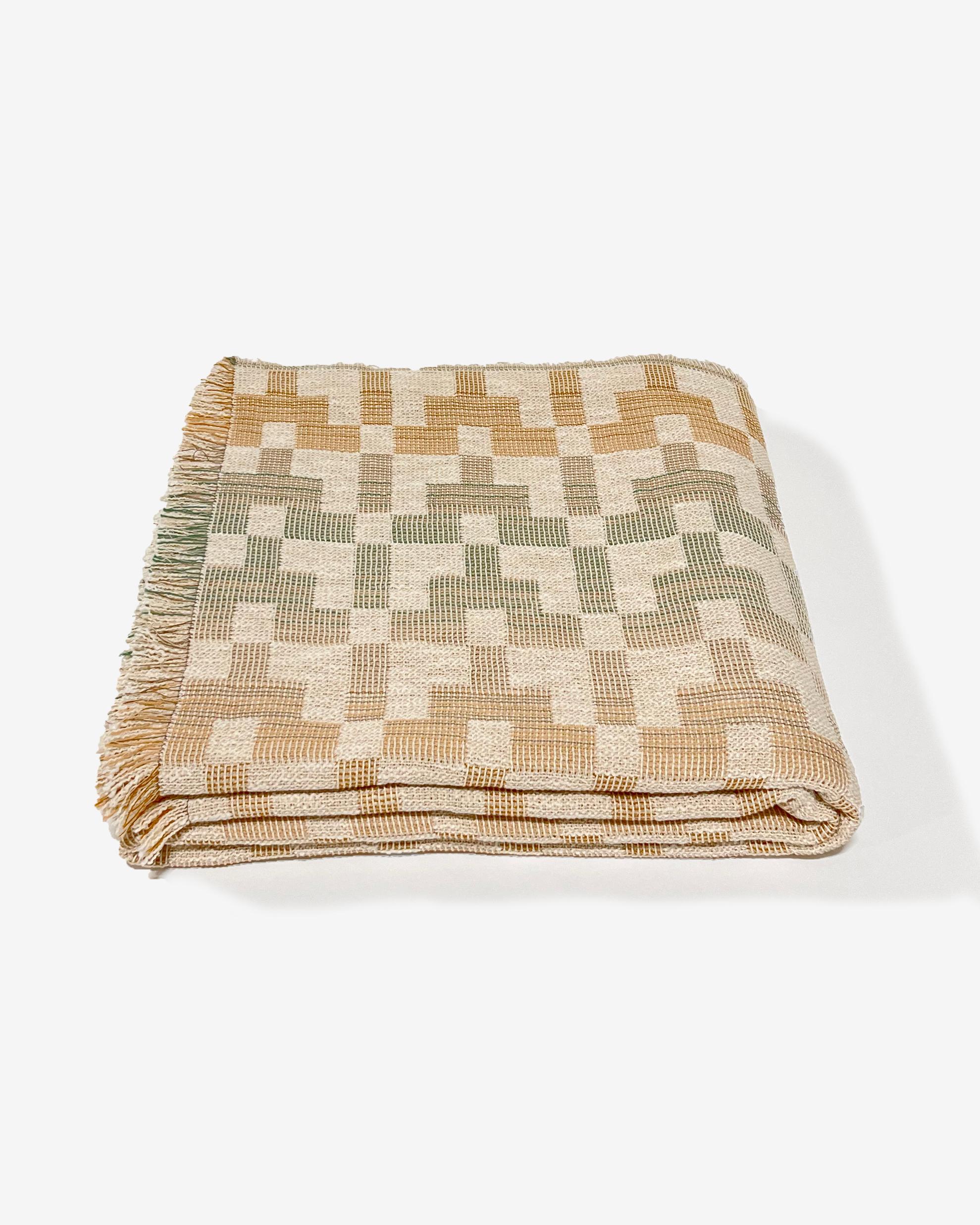 La couverture 'Esme' a été conçue par Folk Textiles, une marque basée à Los Angeles qui se consacre à l'art de vivre. Ce textile est tissé sur un métier à tisser Dobby au Royaume-Uni à partir de coton biologique teint de manière durable en