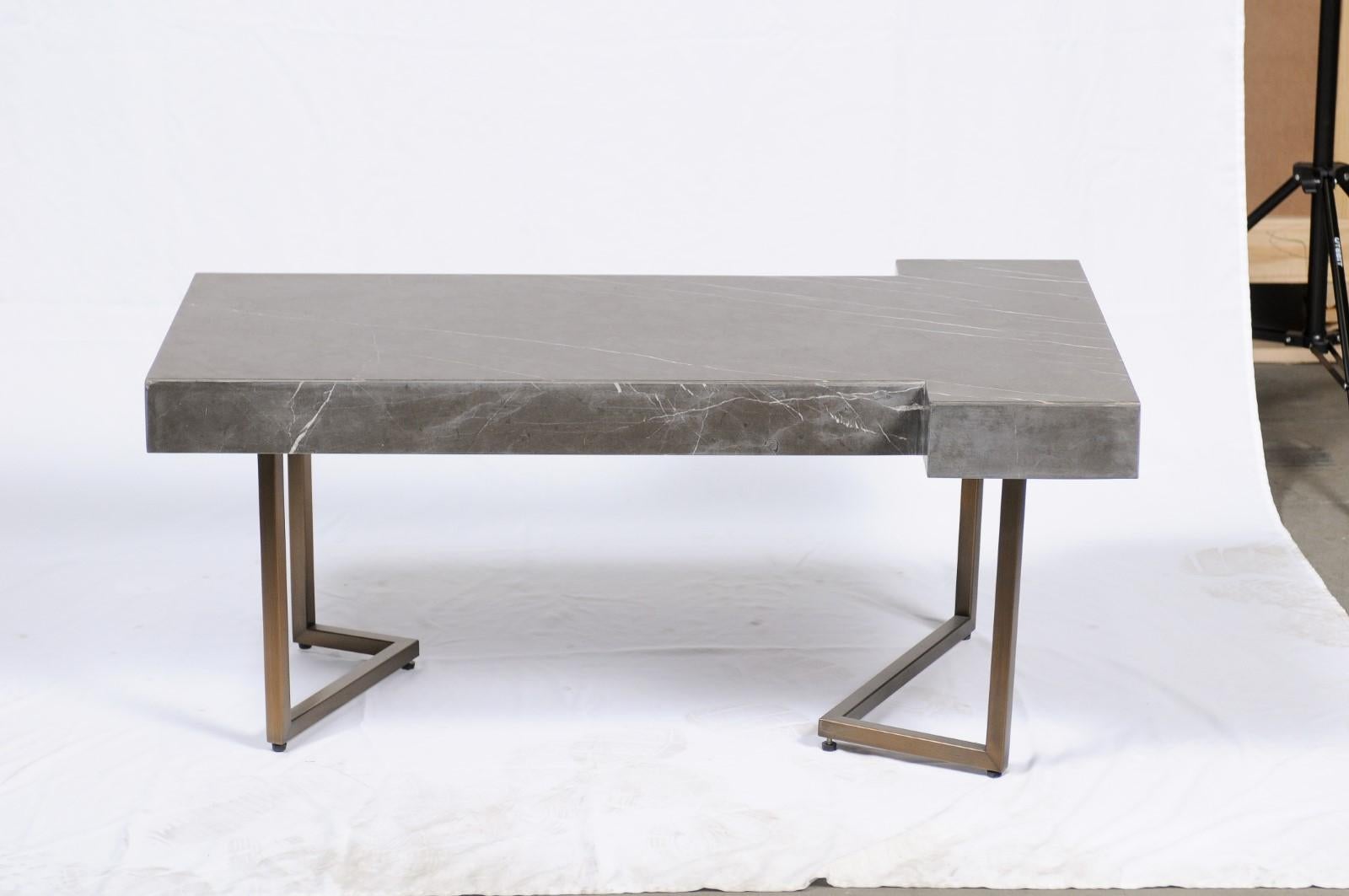 A T-shaped piece of marble rests on an inverted brushed brass base. Darryl Carter's whole home design portfolio reflects his keen sense of style and understanding of composition, proportion and scale. The collection resonates with the familiarity of