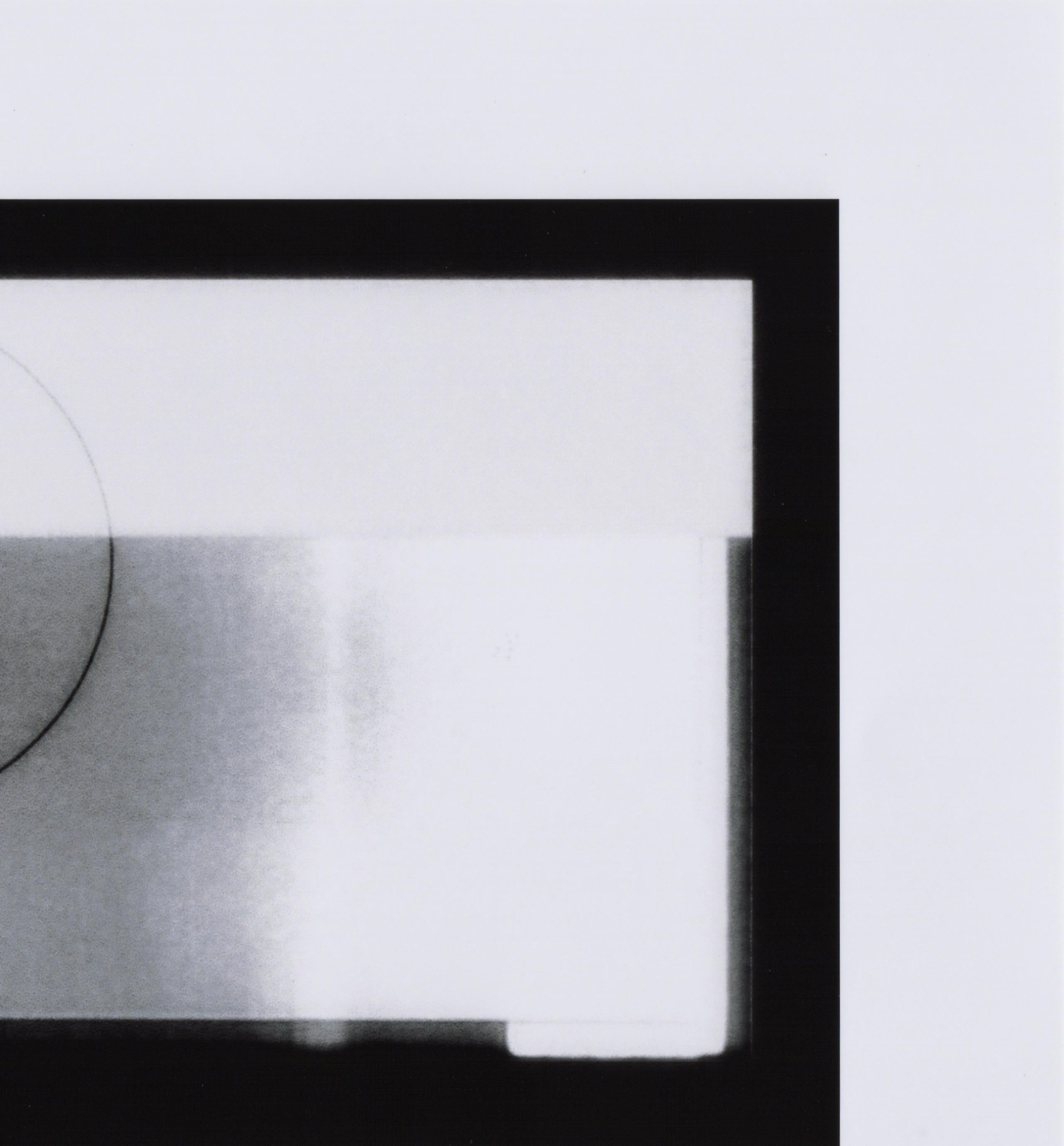 Patty deGrandpre’s “Mimeograph” is a unique abstract 6.25  x 10 inch inkjet print on 9 x 13 inch photo paper in black and white that incorporates a picture taken of a broken television screen. The contrasting hues, grain, and delineated circle of