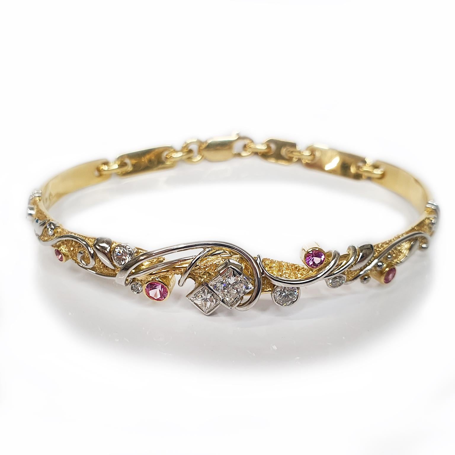 Paul Amey’s bangle was crafted from 18K yellow gold, platinum, diamonds and pink sapphires. This narrow bangle is worn low on the wrist and is finished with Paul Amey’s signature texture with an overlay of platinum “vine”. The rear chain is hand