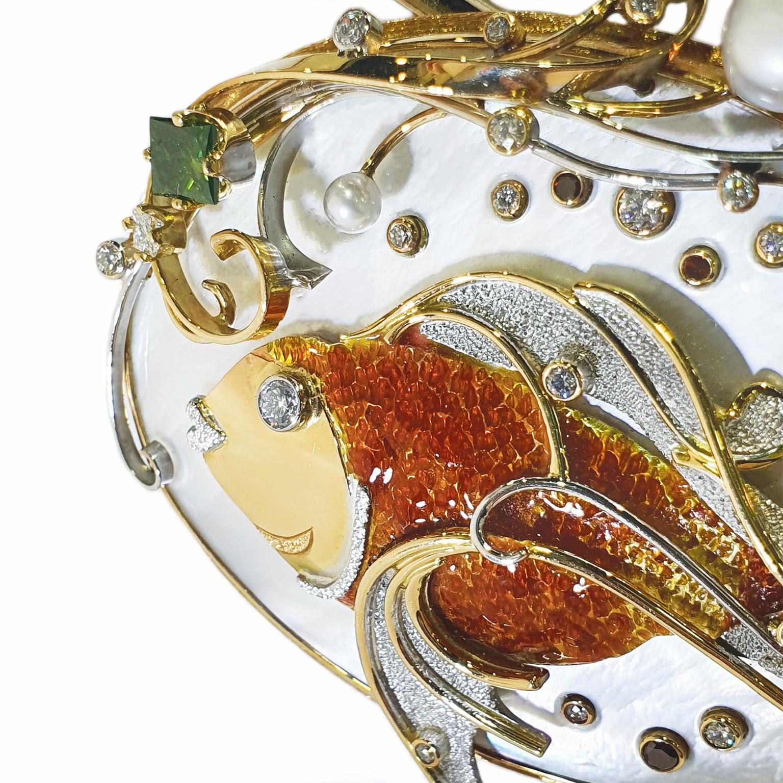 Paul Amey’s Fantail Goldfish pendant was crafted from 18K yellow and white gold with mother of pearl, diamonds and hard enamel.

Paul hand carved the oval base out of mother of pearl creating a “fluid” background for the stylized fantail goldfish.