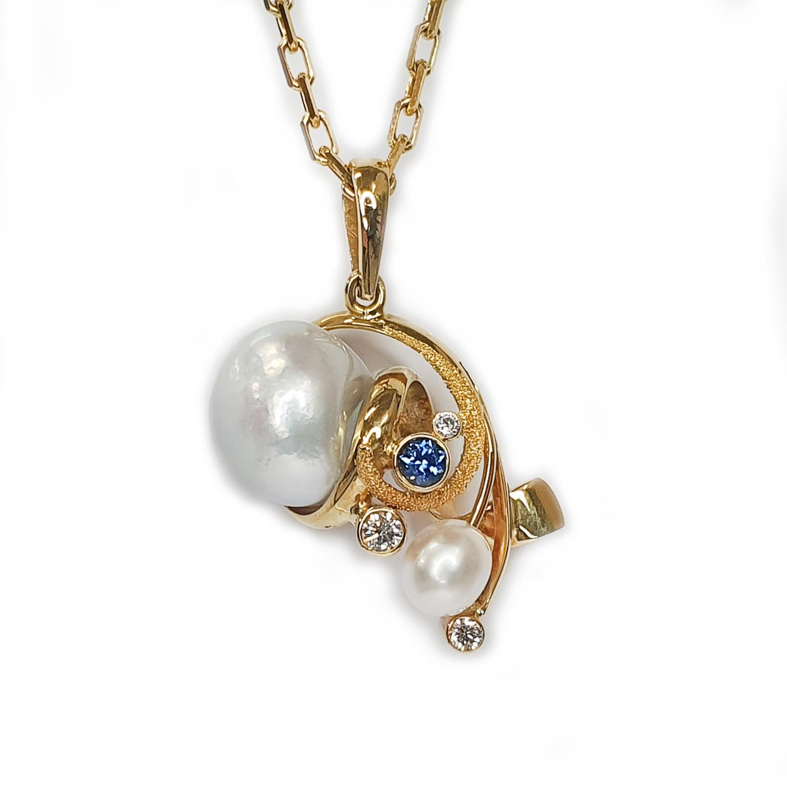 Paul Amey’s Broome keshi pearl and blue sapphire pendant was crafted from 18K yellow gold. The pearls are from Broome, Western Australia and are 12mm and 5.5mm. The pendant features a natural 3.5mm blue sapphire and also contains three E/F VS SI1