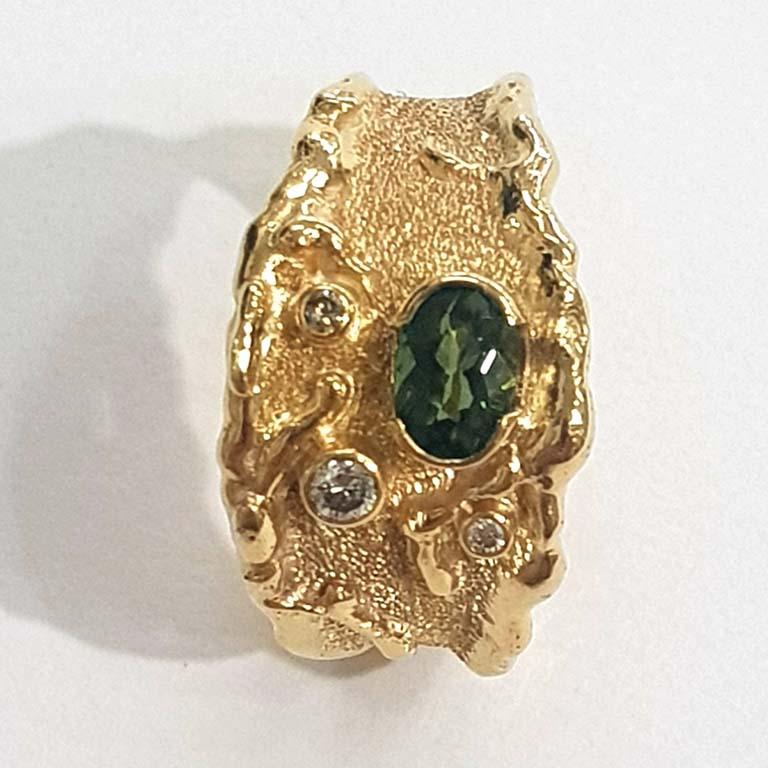 Paul Amey’s signature molten edge ring is a totally unique and completely handcrafted and created by Paul Amey. This natural green tourmaline and diamond ring was crafted from 9K yellow gold. This molten edge ring features a 6mm x 4mm oval green