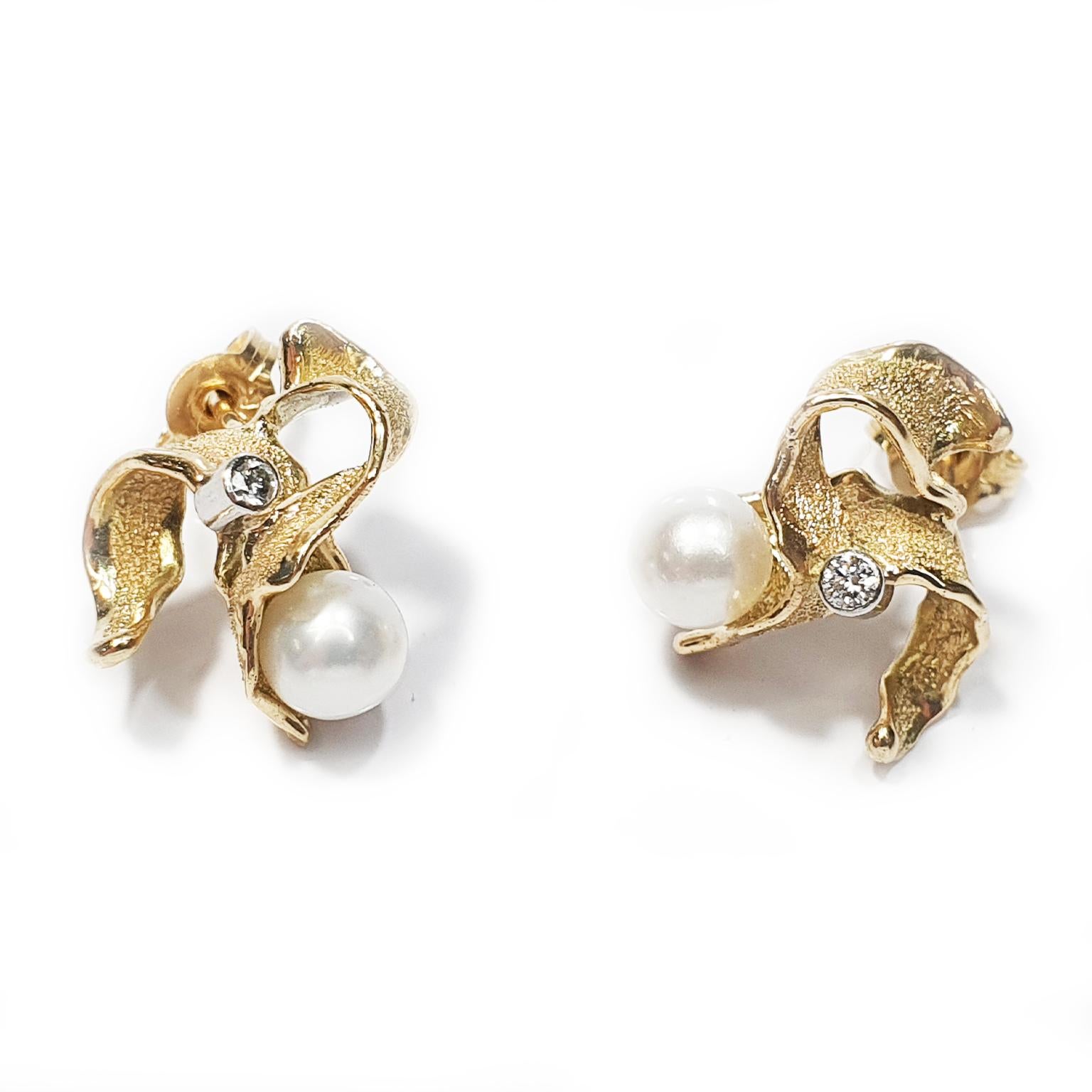 Paul Amey’s “Orchid” signature molten edge freshwater pearl earrings resemble a stylized orchid and are crafted from 9K yellow gold and platinum and each earring features a 2pt diamond and finished with Paul Amey’s signature texture. The earrings