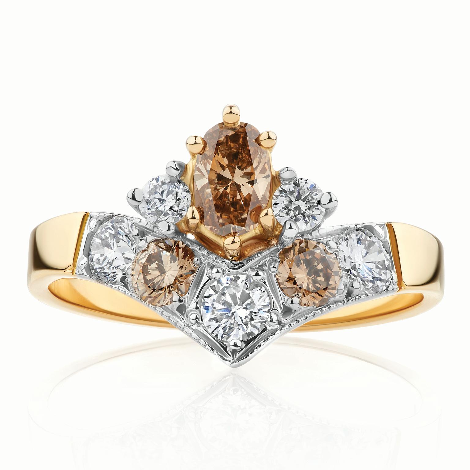 La bague en diamants de type Argyle géométrique de Paul Amey a été réalisée en or jaune 18 carats avec un plateau en or blanc et des griffes en or blanc sur les diamants latéraux. Le diamant présenté est un diamant ovale C6 de type Argyle de 32pt
