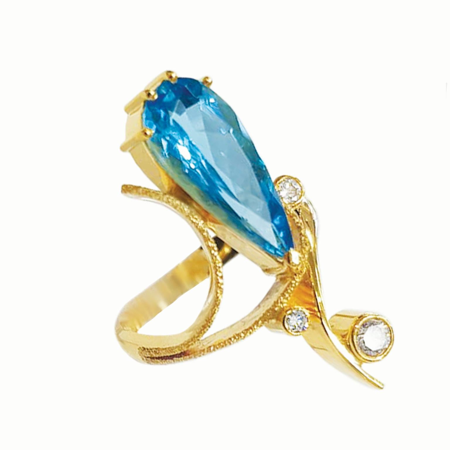 Unveiling a masterpiece by Paul Amey: a luxurious 9ct yellow gold ring adorned with a captivating Swiss blue pear-shaped topaz and diamonds. This handcrafted creation is a true embodiment of elegance and sophistication.

The focal point is a