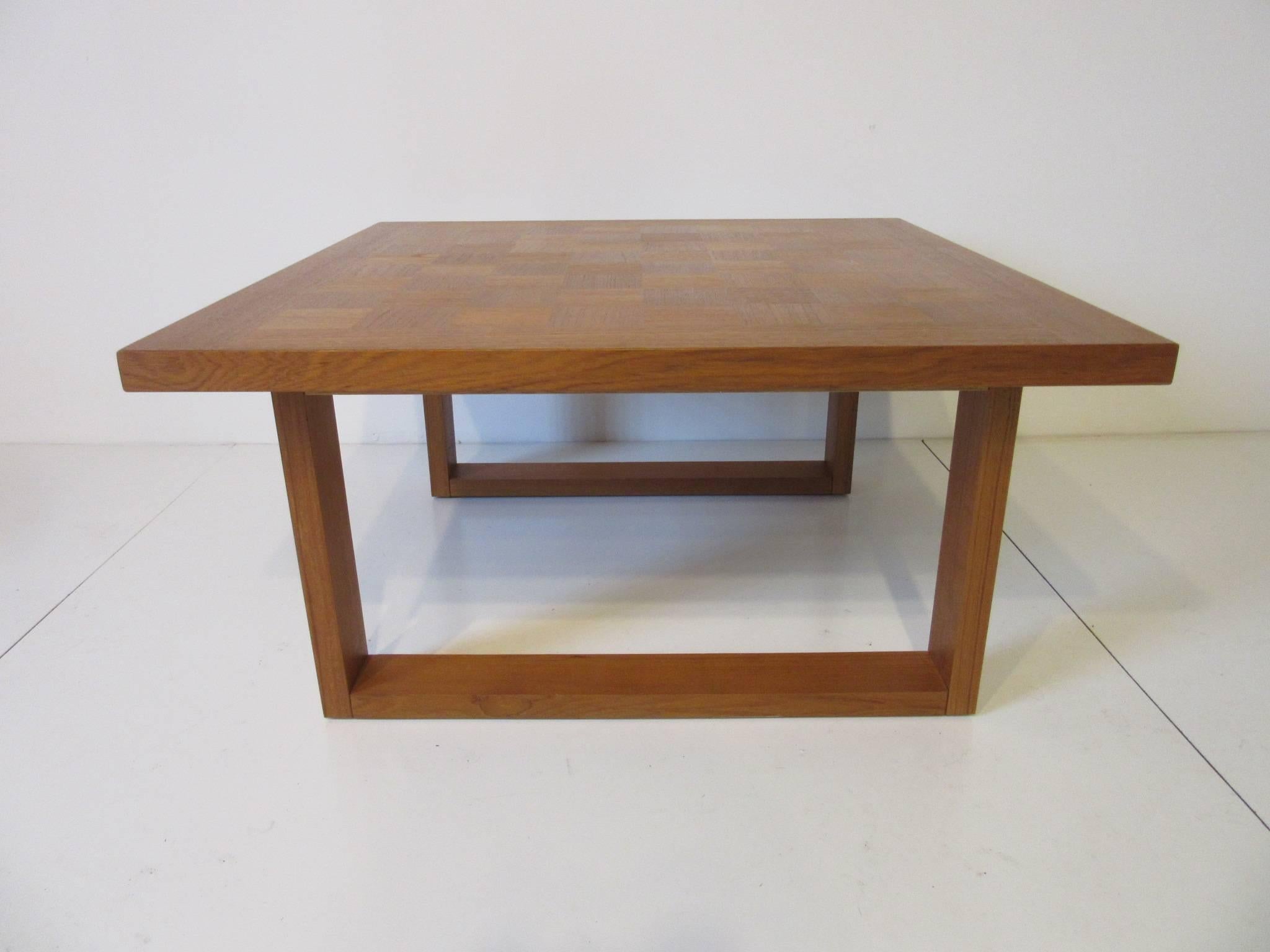 A sled leg teak wood coffee table with checker board styled top manufactured by the Cado Furniture company, Denmark.