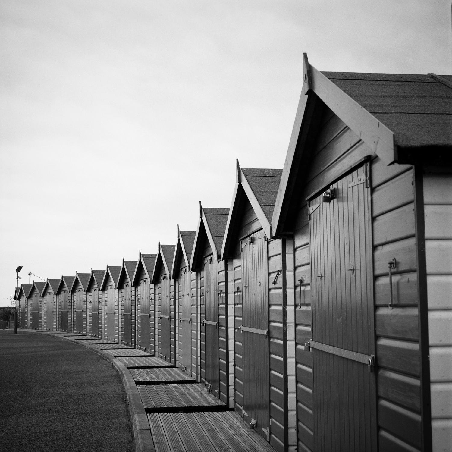[Featured in Italian Vogue. The print will not display the watermark]

Edition 1/10 - Beach Huts II, Dawlish Warren, Devon, Silver Gelatin Photograph

Edition of 10 + 5 APs.
Front: Signature and edition number with artists blind stamp.  
Back: Ink
