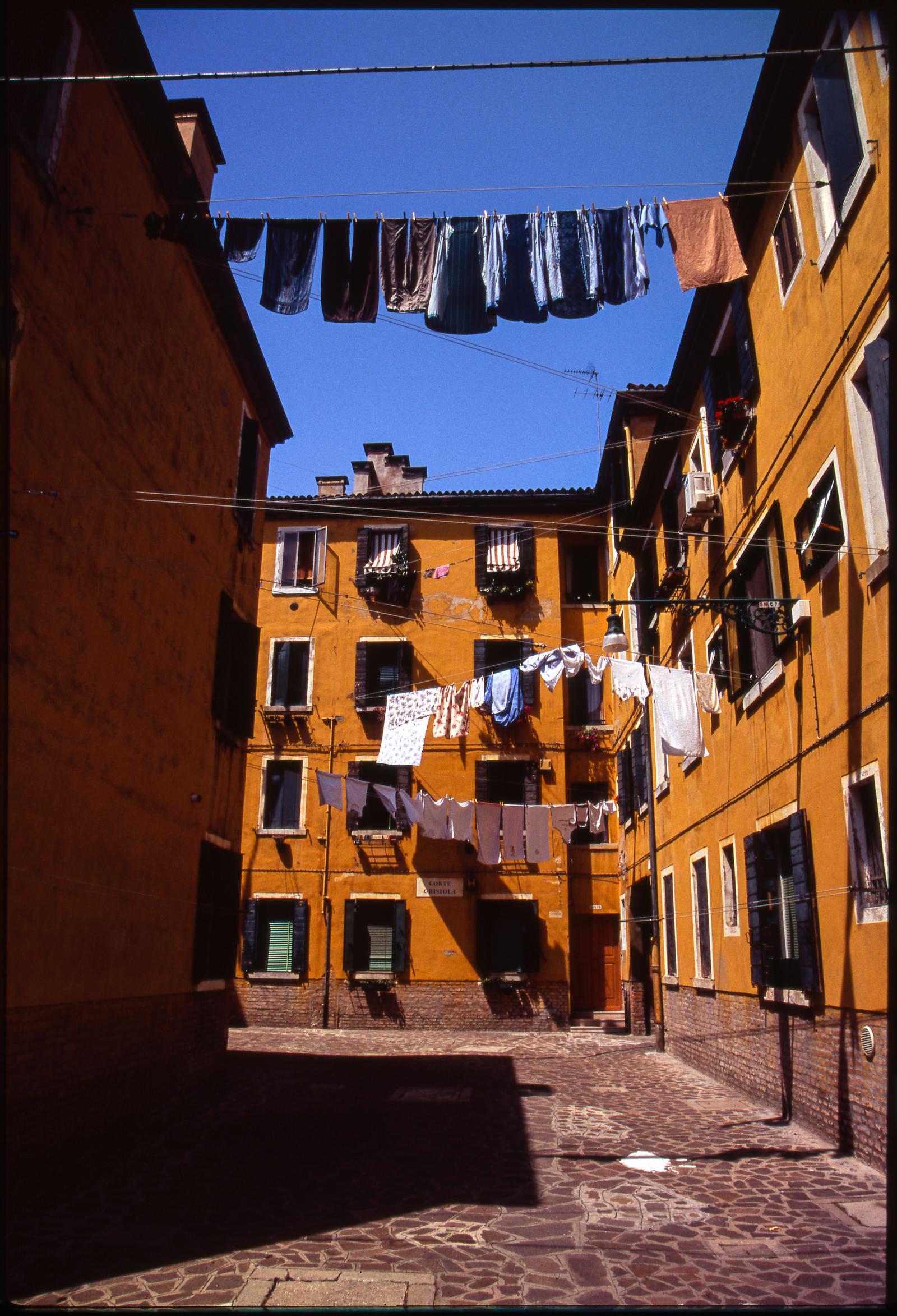 [Featured in Italian Vogue. The print will not display the watermark]

Edition 1/10 - Laundry in Venetian Courtyard, Venice, Italy , C-Type Photograph

Edition of 10 + 5 APs.
Front: Signature and edition number with artists blind stamp.  
Back: Ink