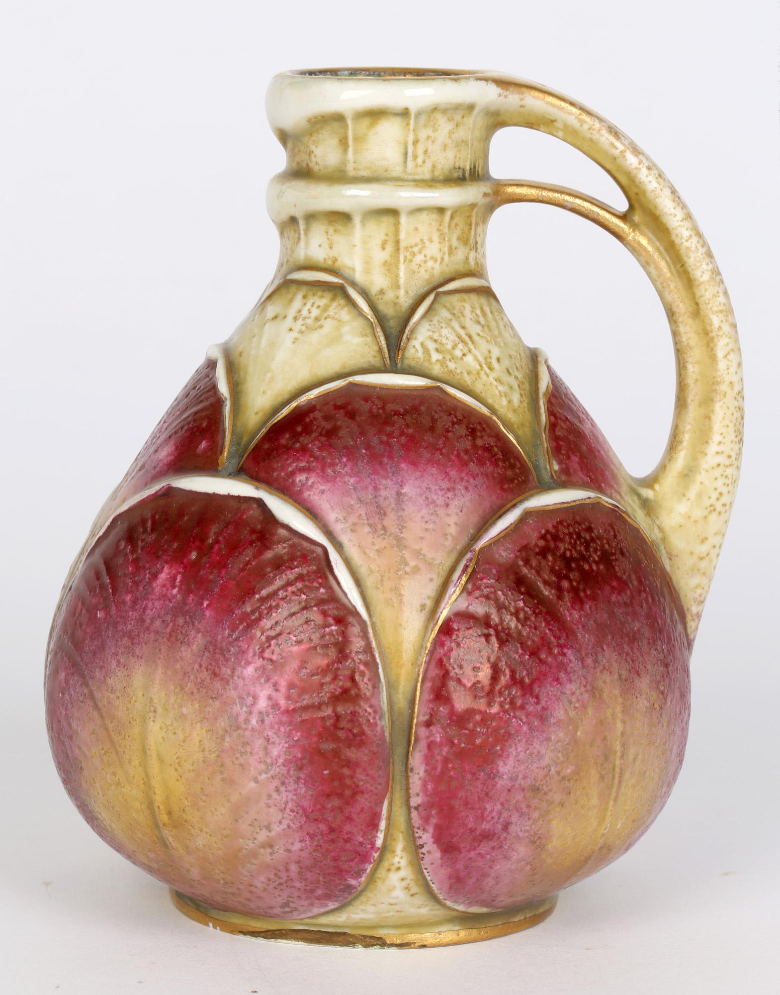 Un vase à poignée Art Nouveau autrichien très élégant avec de grands motifs de feuilles superposées par Paul Dachsel pour Alexandra Porcelain Works Turn-Teplitz et datant du début du 20e siècle. Le vase en poterie est de forme arrondie et bulbeuse,