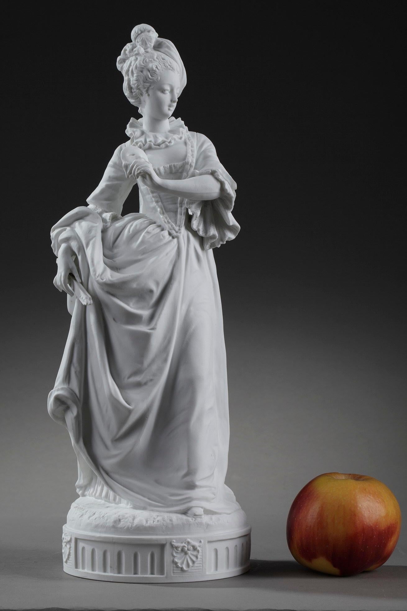 This porcelain bisque statue depicts a young woman in a ball gown, holding a mask and a fan, in 18th century taste. She is wearing an elegant dress à la française, with a richly decorated stomach piece, a large skirt and a coat dress tied at the