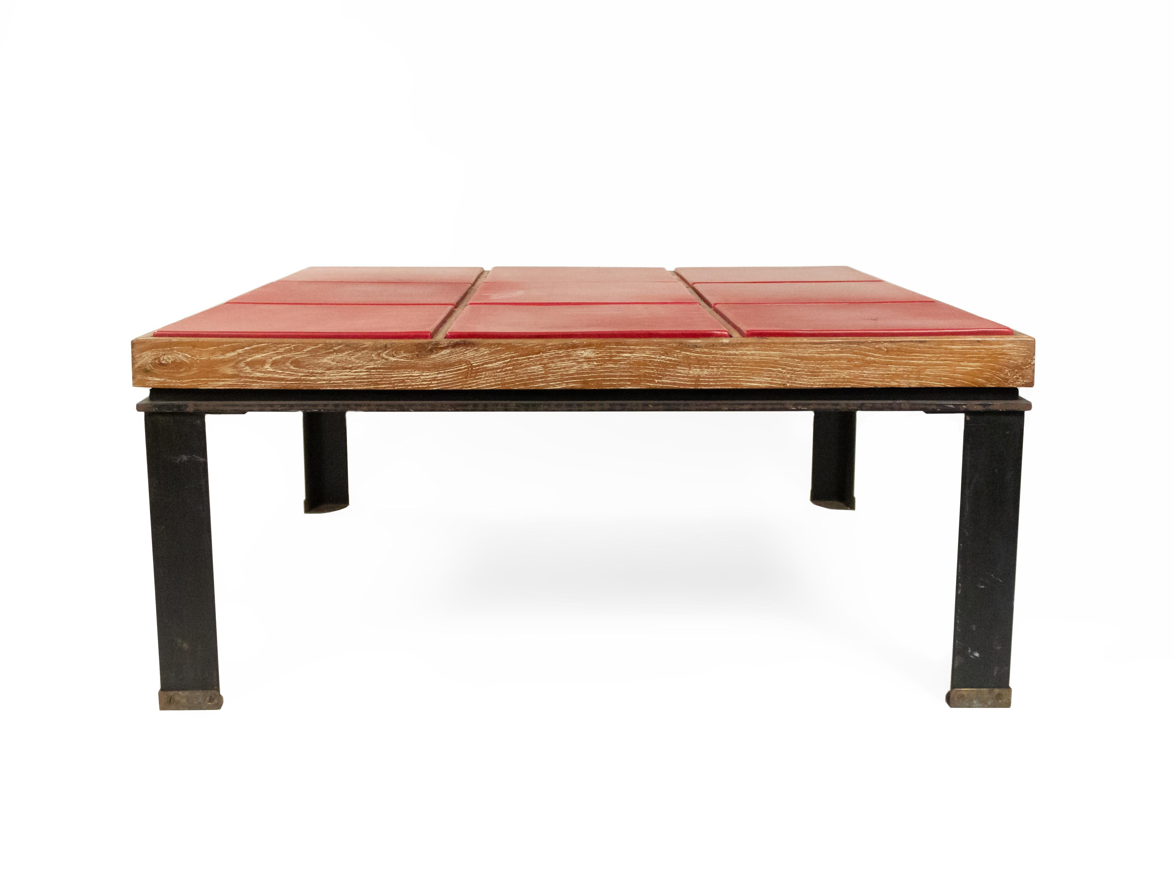 Midcentury rectangular red leather and cerused oak coffee table in the style of Paul Dupré-Lafon. Table has a blackened steel base and legs that end in bronze feet. Top is composed of cerused oak and nine leather square insets.