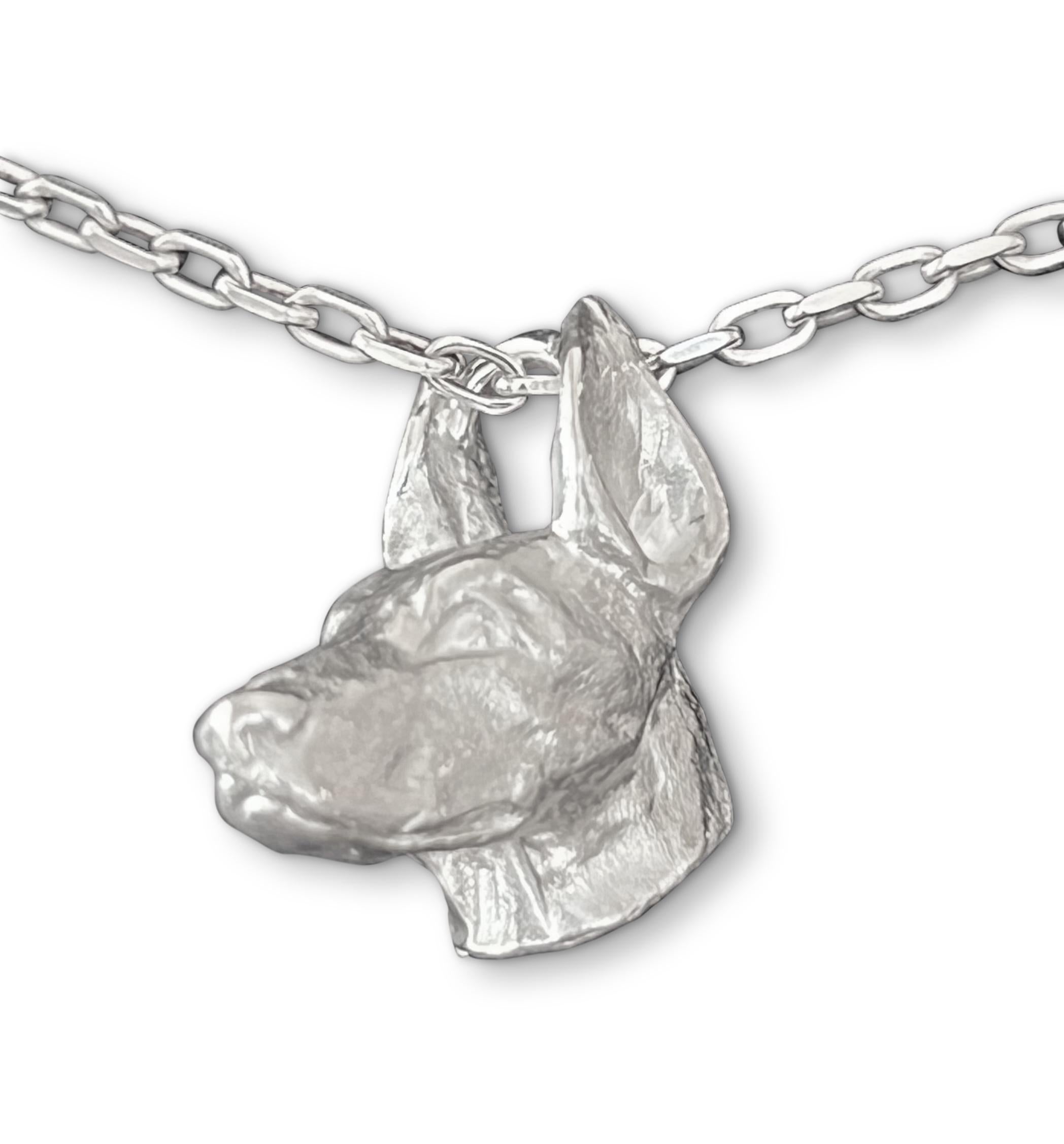 Discover the exquisite art of England’s renowned miniature wildlife sculptor, PAUL EATON, with his sculpted sterling silver Doberman dog charm or pendant.    Each bespoke animal pendant is meticulously carved, individually cast, and carefully