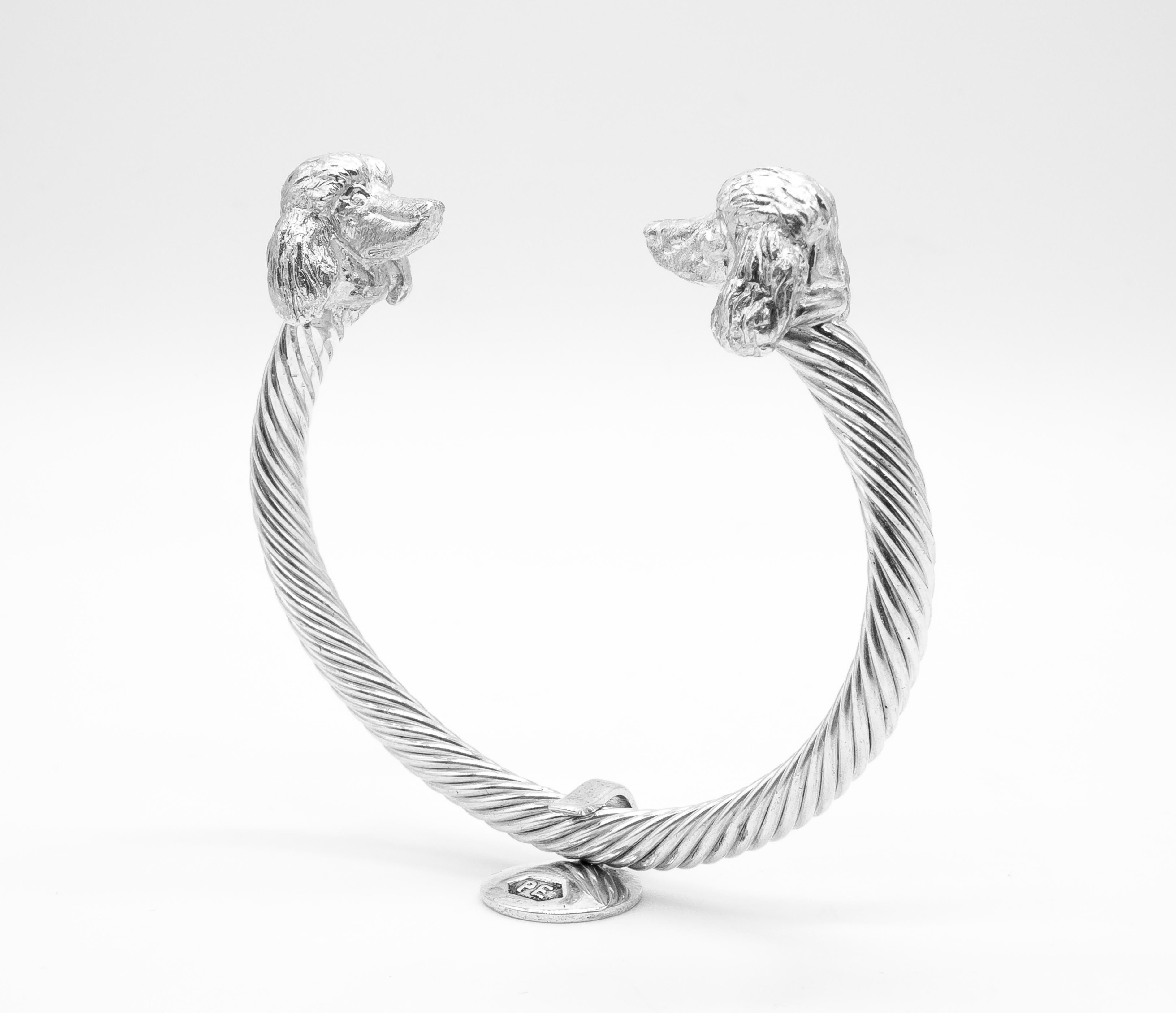 Le miniature di cani intagliate a mano su misura dello scultore britannico PAUL EATON, che raffigurano teste di cani barboncini, sono bellissime opere d'arte su un braccialetto intrecciato in argento sterling. I braccialetti per cani su misura di