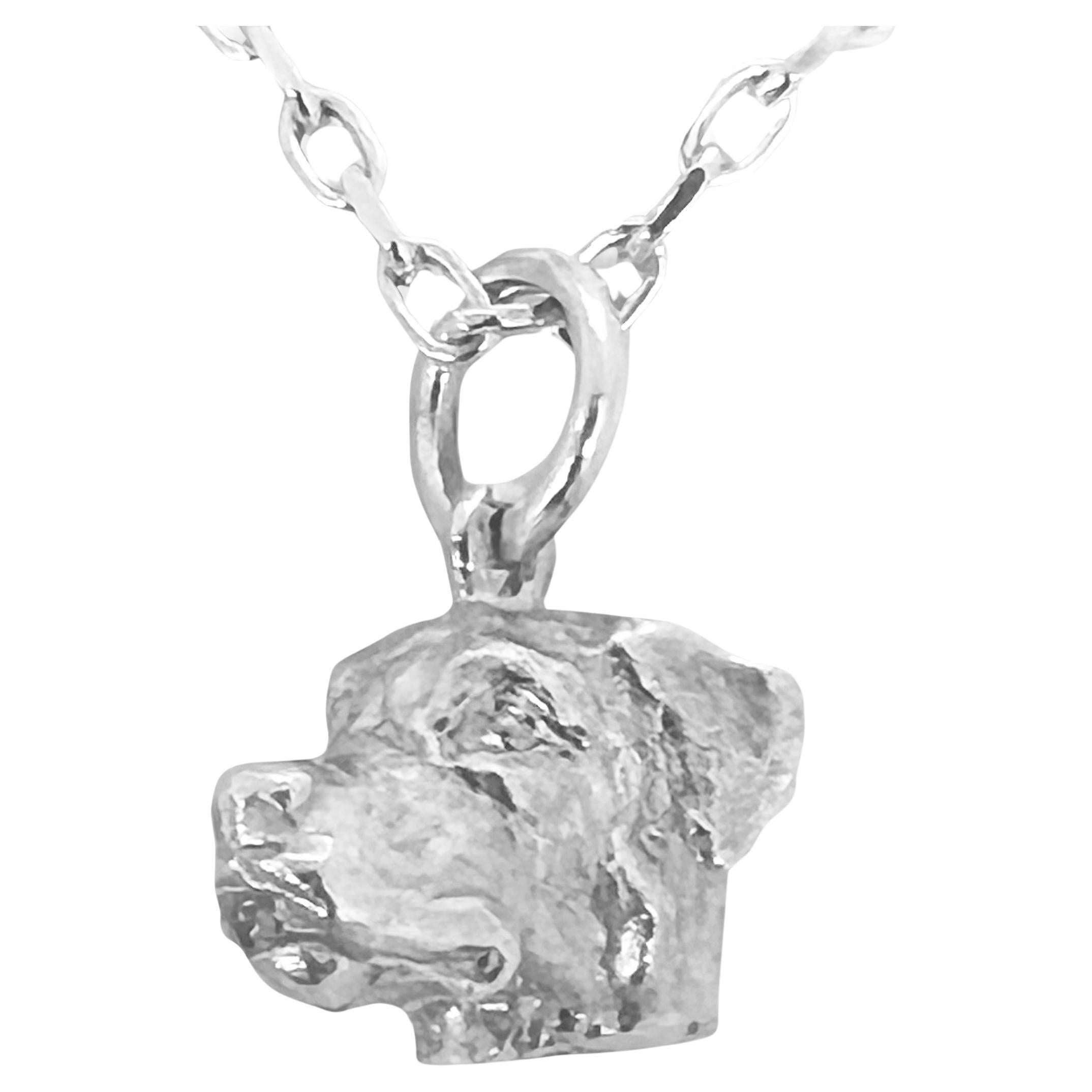 Paul Eaton scolpisce un rottweiler in miniatura  in un charm o un ciondolo in argento sterling