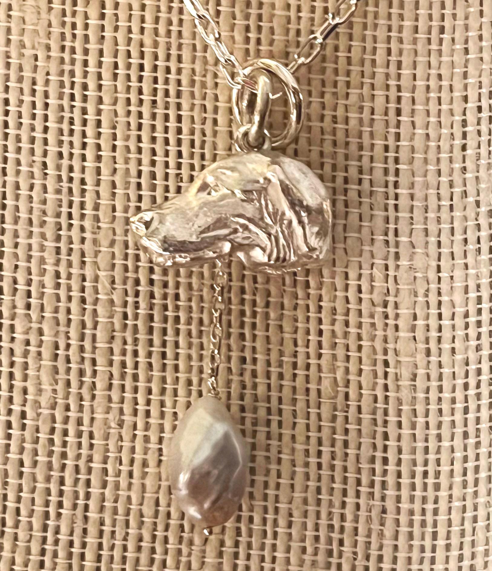 Miniature wildlife artist, Paul Eaton from England, hand sculpted a Retriever dog head pendant which is elegantly framed with one or two drop freshwater pearls. The bespoke Retriever dog sculpture is made into jewelry you can wear close to your