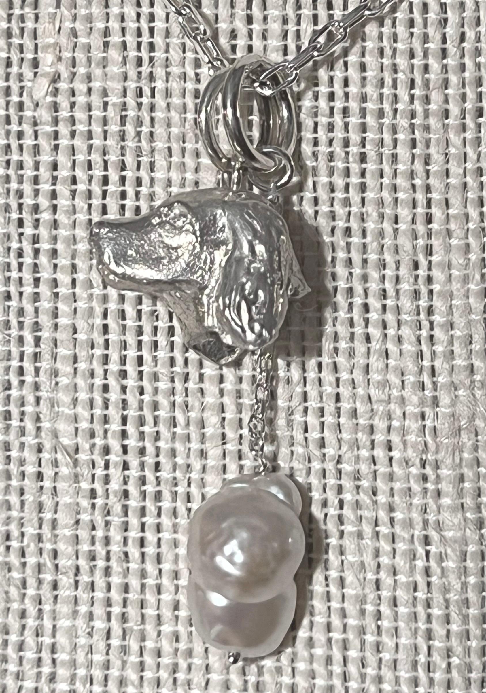      Miniature wildlife artist, Paul Eaton from England, hand sculpted a sterling silver Spaniel dog head pendant which is elegantly framed with one or two drop freshwater pearls.    The bespoke Spaniel dog sculpture is made into jewelry you can