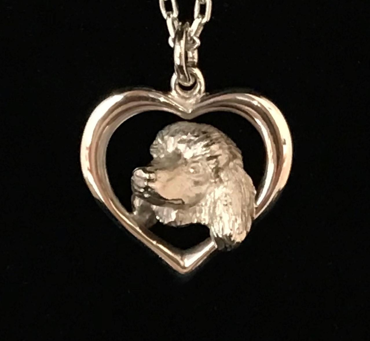 From Great Britain Paul Eaton VPRMS MAA hand carved a Poodle pendant an elegant sterling-silver miniature dog sculpture made into a jewelry piece you can wear close to your heart. The title of the pendant is 