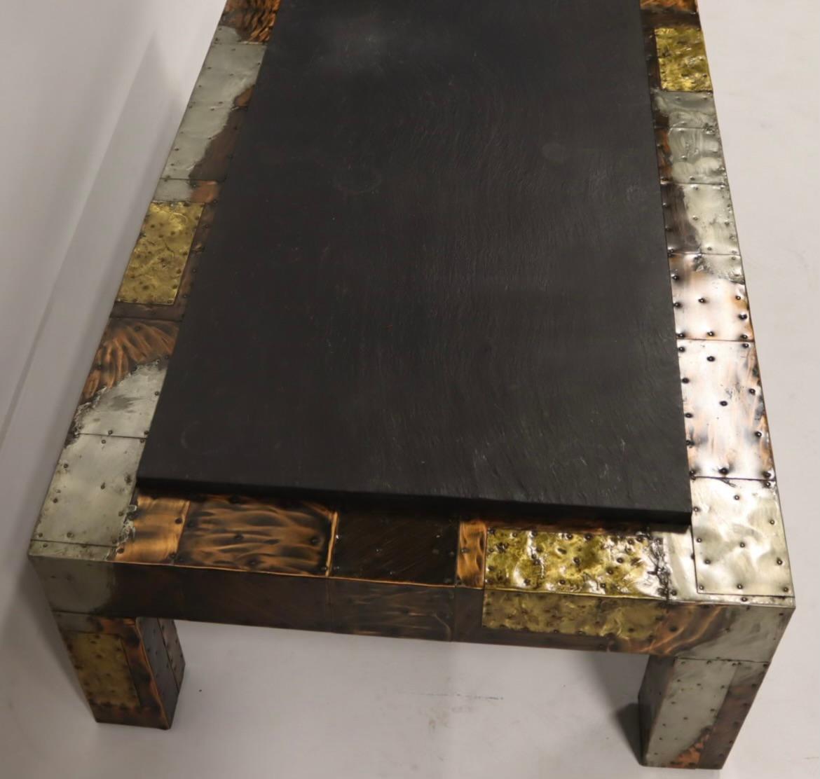 The Paul Evans slate patchwork coffee table is a notable piece from the mid-century modern era, created by the American designer and sculptor Paul Evans. This table is characterized by its unique patchwork design, incorporating various metals such