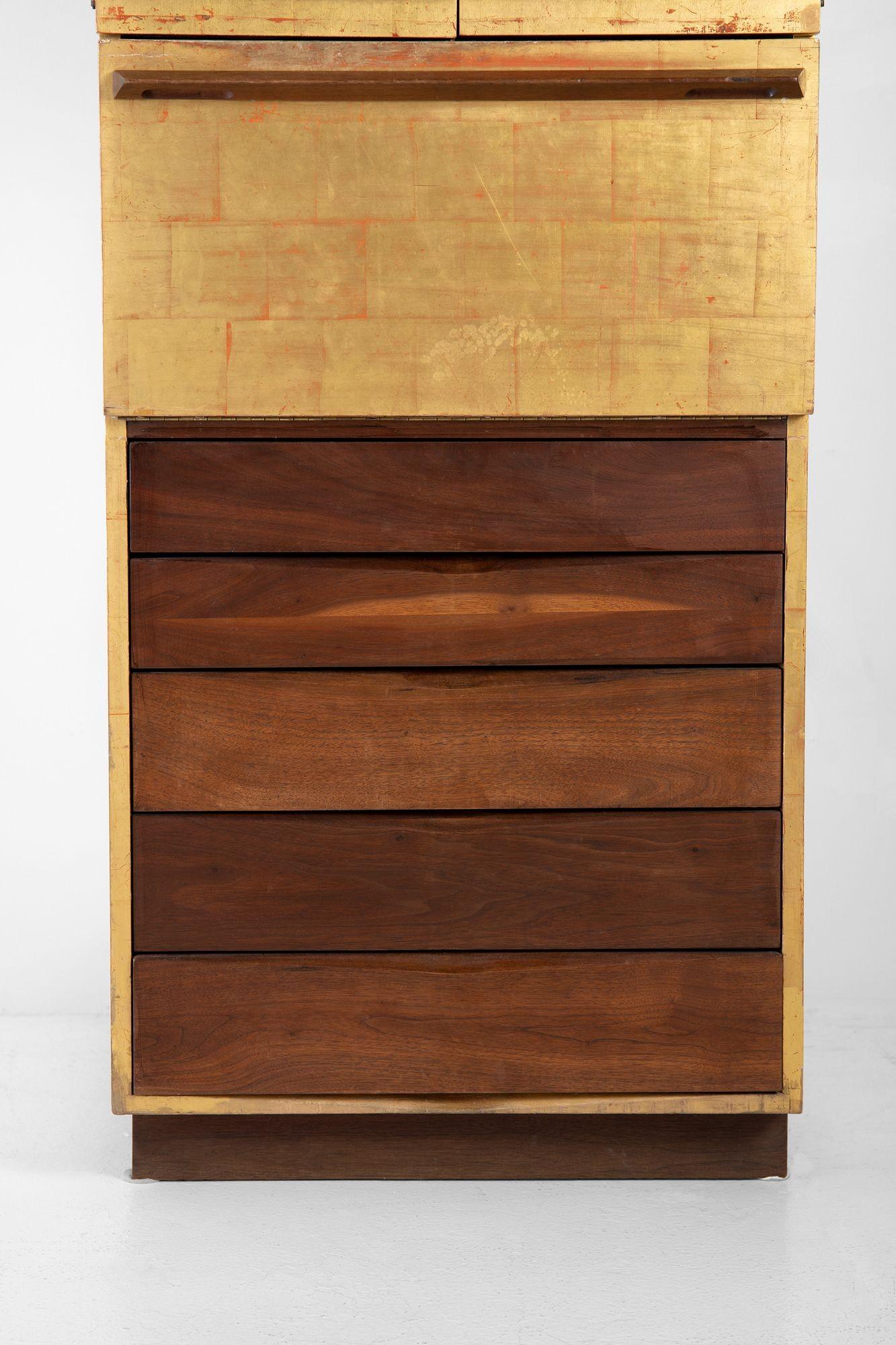 This early studio craft 23 Karat gold leafed cabinet was made as a collaboration between Paul Evans and Phillip Lloyd Powell in the mid 1960s.
 
 The upper storage compartment unlatches to reveal two adjustable felt-lined shelves. The center