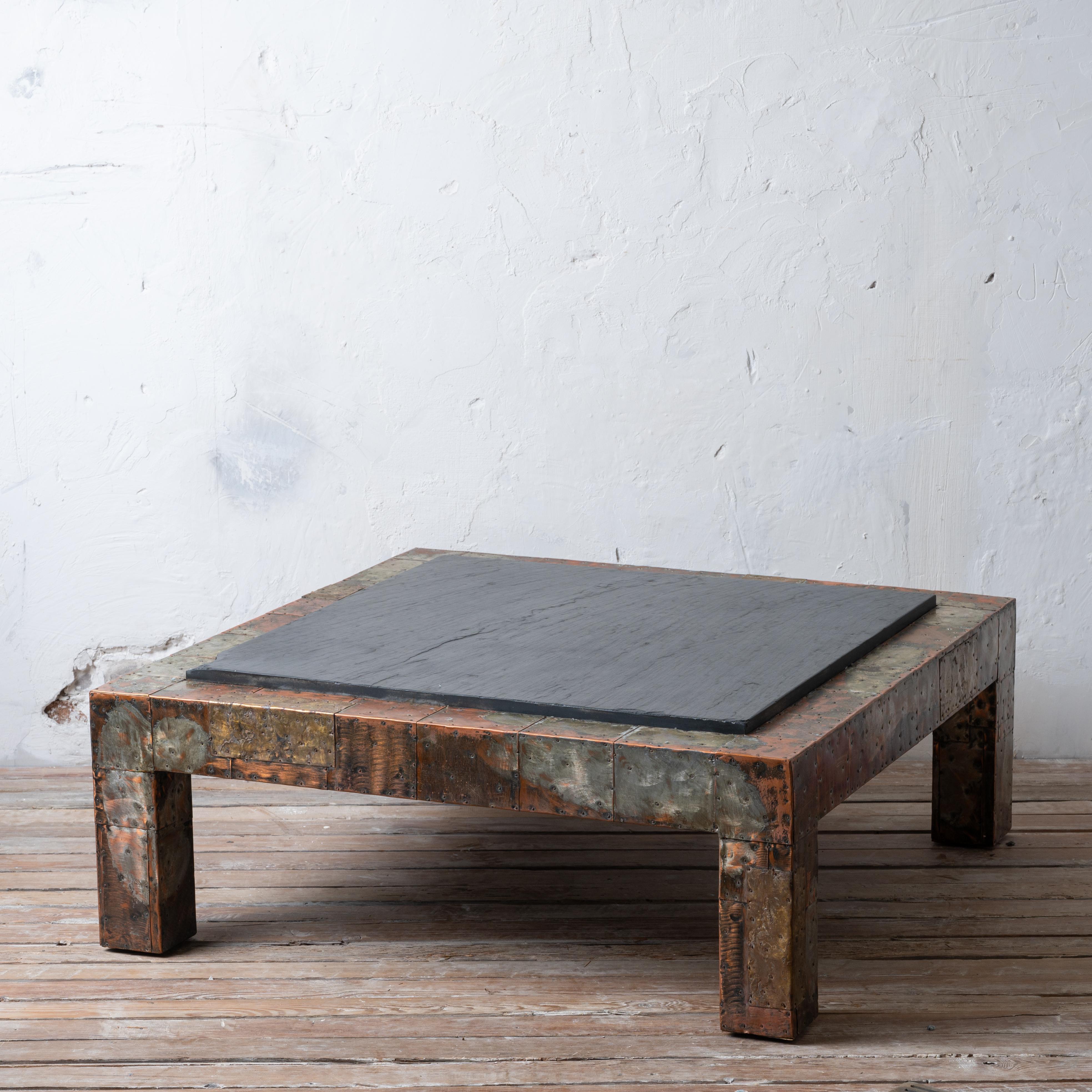 Paul Evans 
(American, 1931-1987) 

Brutalist mixed metal patchwork coffee table with original slate top, circa 1970. 

42 inches wide and deep by 16 ½ inches tall 

