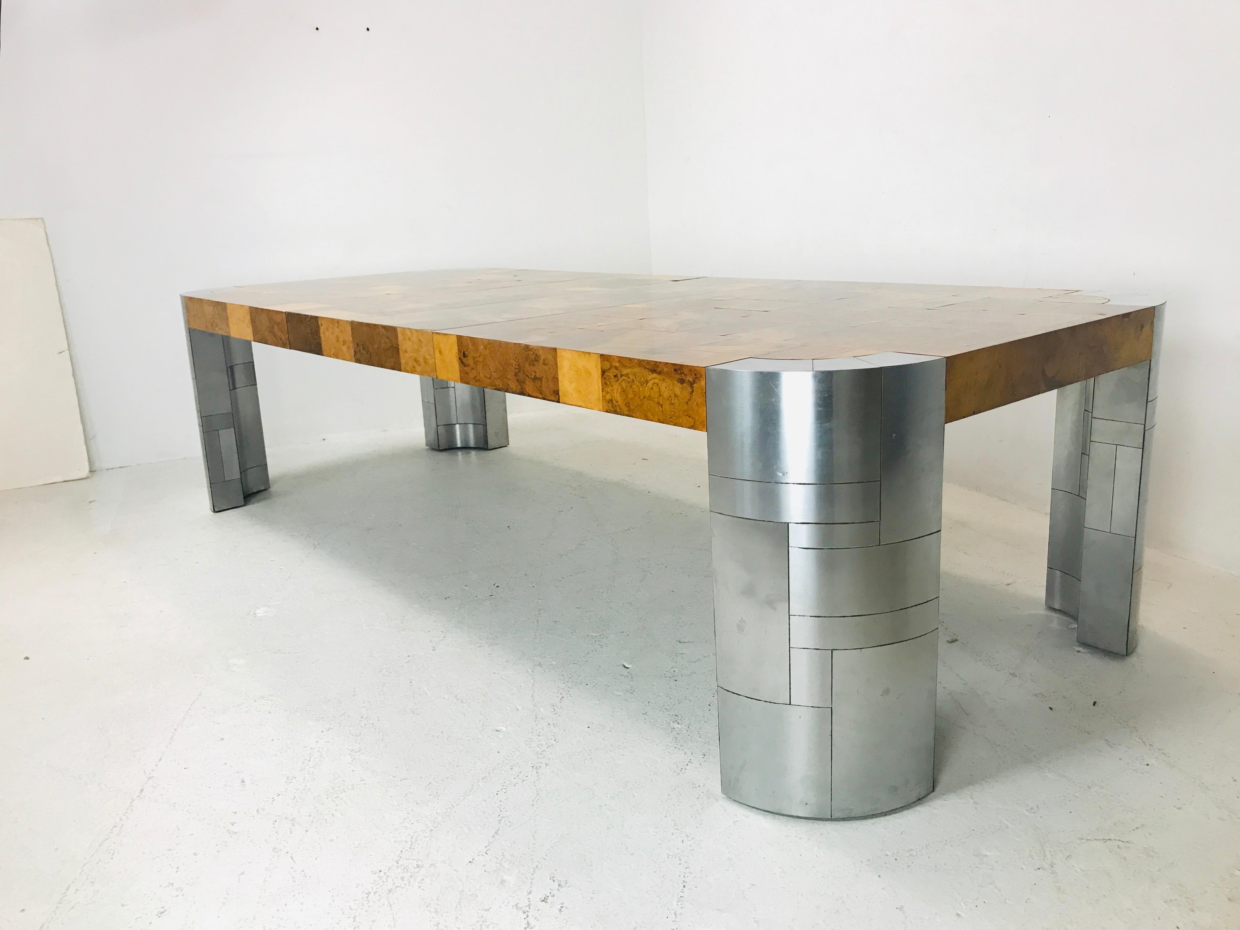 Large, commanding patchwork burl wood dining table with thick chrome legs. Includes 2 leaves that measure 14.75