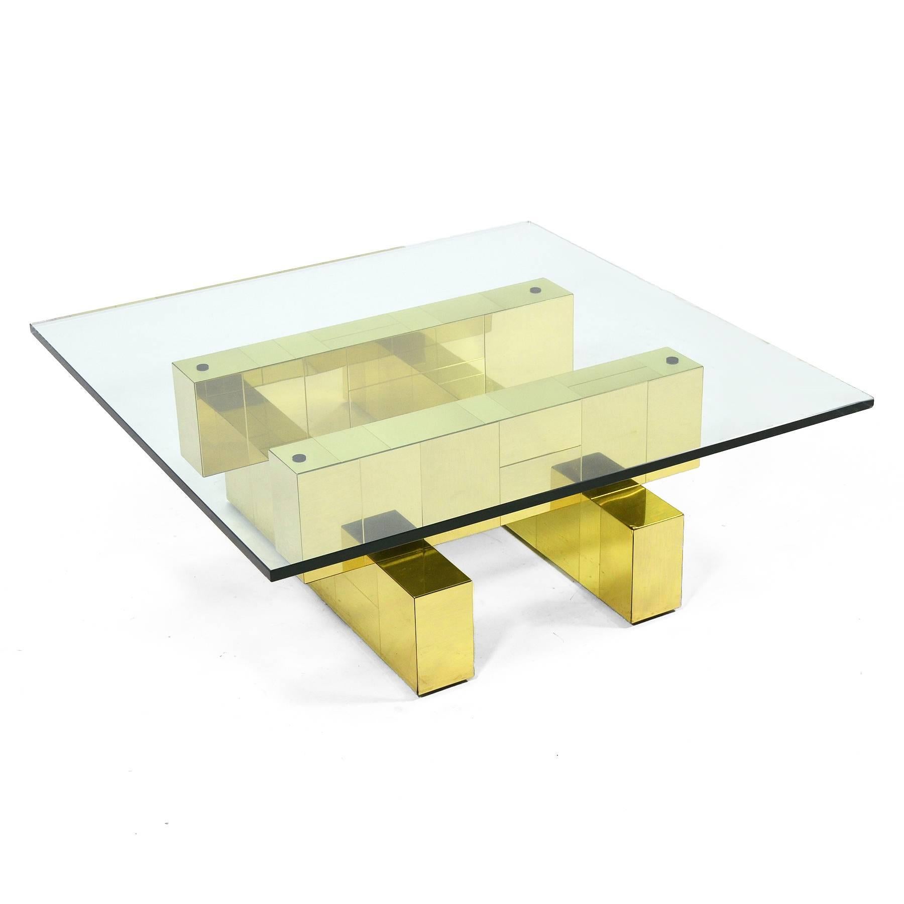 This table from Evans' PE200 series features a strong architectural quality and is clad in a brass patchwork. 

The table is signed with the signature plate (“An original Paul Evans”) on the underside of one of the top beams.