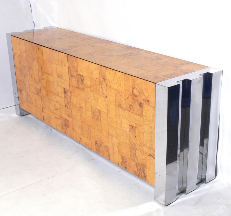 Burl wood and chrome cityscape credenza, designed by Paul Evans for Directional. It offers a voluminous amount of storage with four doors that open to reveal large storage compartments with adjustable shelves. It is a versatile size and can be used