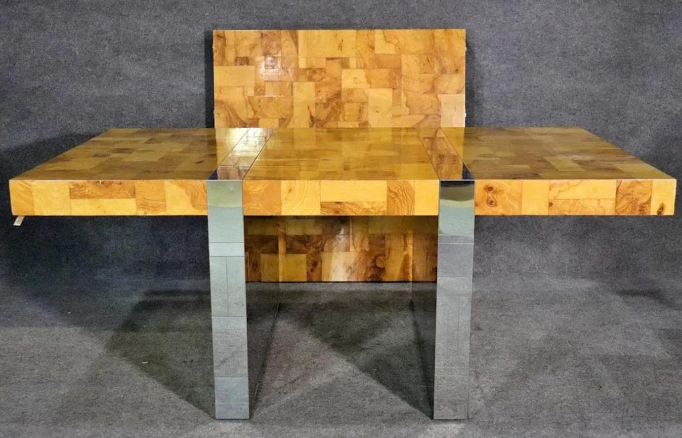 Stunning mid-century modern dining table designed by Paul Evans for his Cityscape collection. Featuring burled olive wood and chrome patchwork, and a large 43 3/4