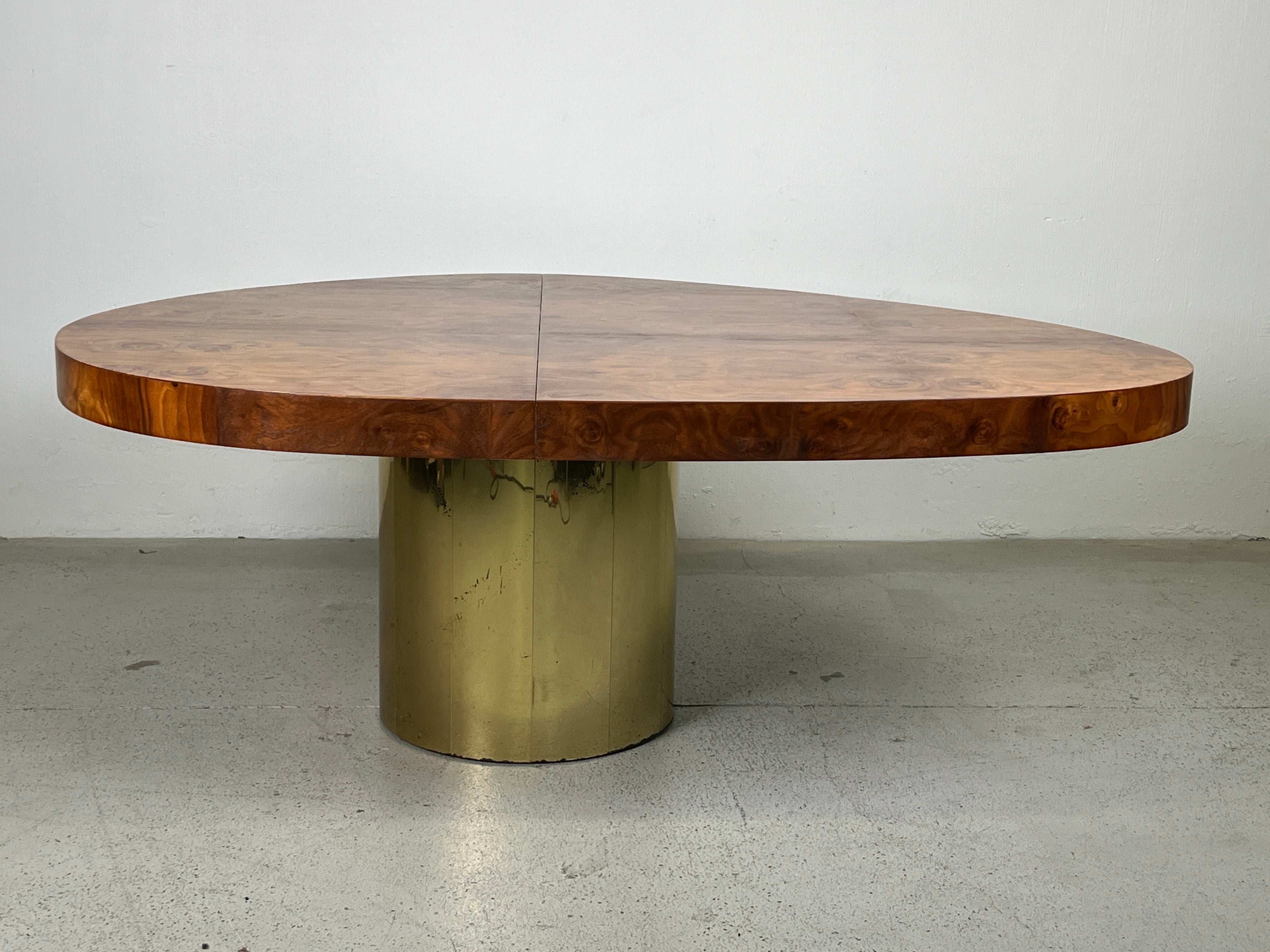 An unusual asymmetrical cantilevered dining table with  book matched burl top and patinated brass base.  Designed by Paul Evans for Directional. 