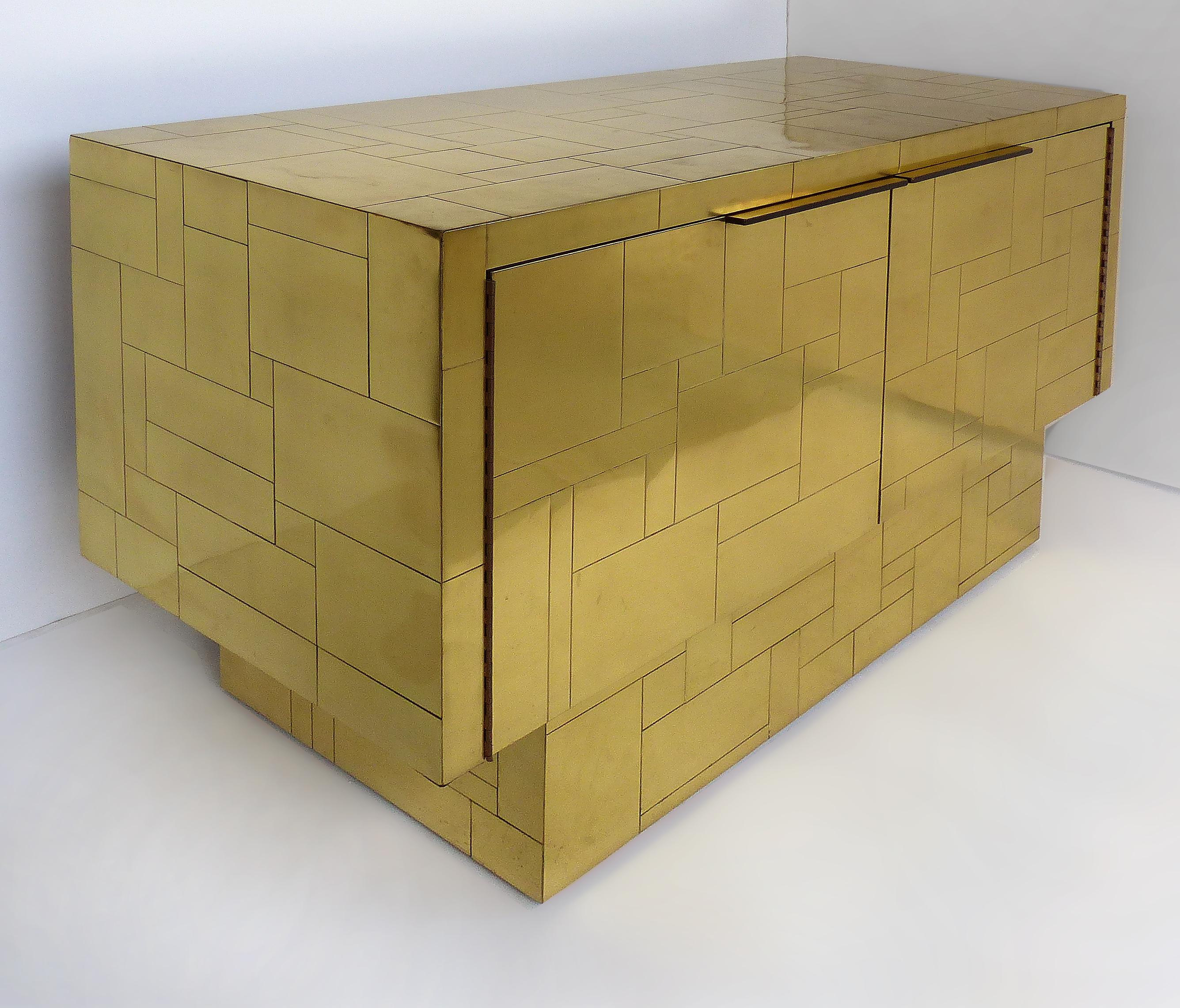 Paul Evans Directional brass cityscape cabinet credenza with 2 doors

Offered for sale is a brass Paul Evans cityscape two-door credenza cabinet for Directional Furniture. The two doors open to reveal open shelves. The upper cabinet rests upon a