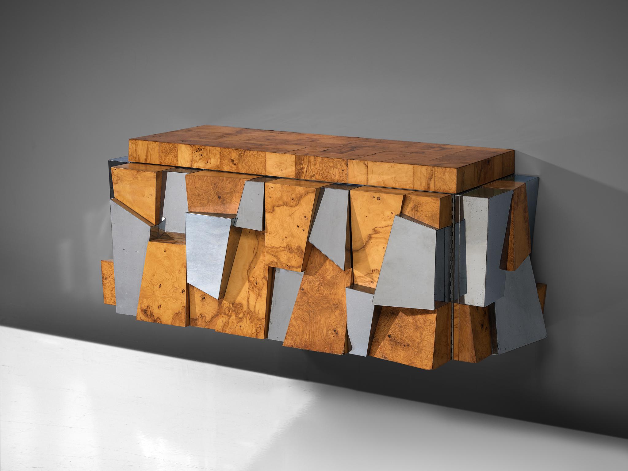 Paul Evans for Directional, 'Faceted' wall-mounted cabinet, chromed steel, olive burl, glass, United States, 1970s

A sturdy wall-mounted sideboard by Paul Evans for Directional. The piece is an excellent example of how Evans’ Cityscape series