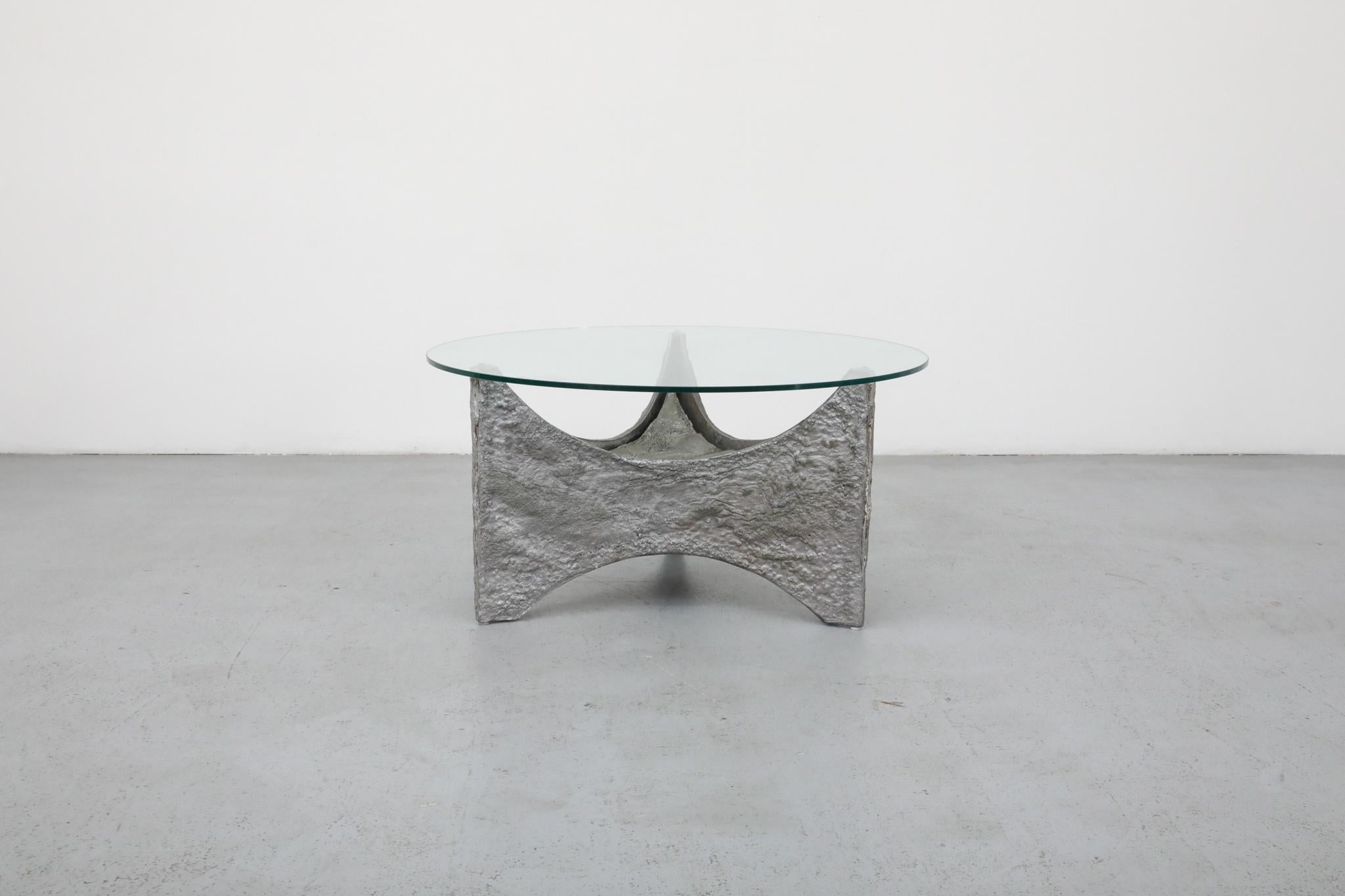Table d'appoint ou table basse du milieu du siècle, d'inspiration brutaliste de Paul Evans, avec un plateau rond en verre transparent et une base texturée et sculpturale. Joli mariage de lignes épurées et de reliefs tactiles. Patins blancs sur la