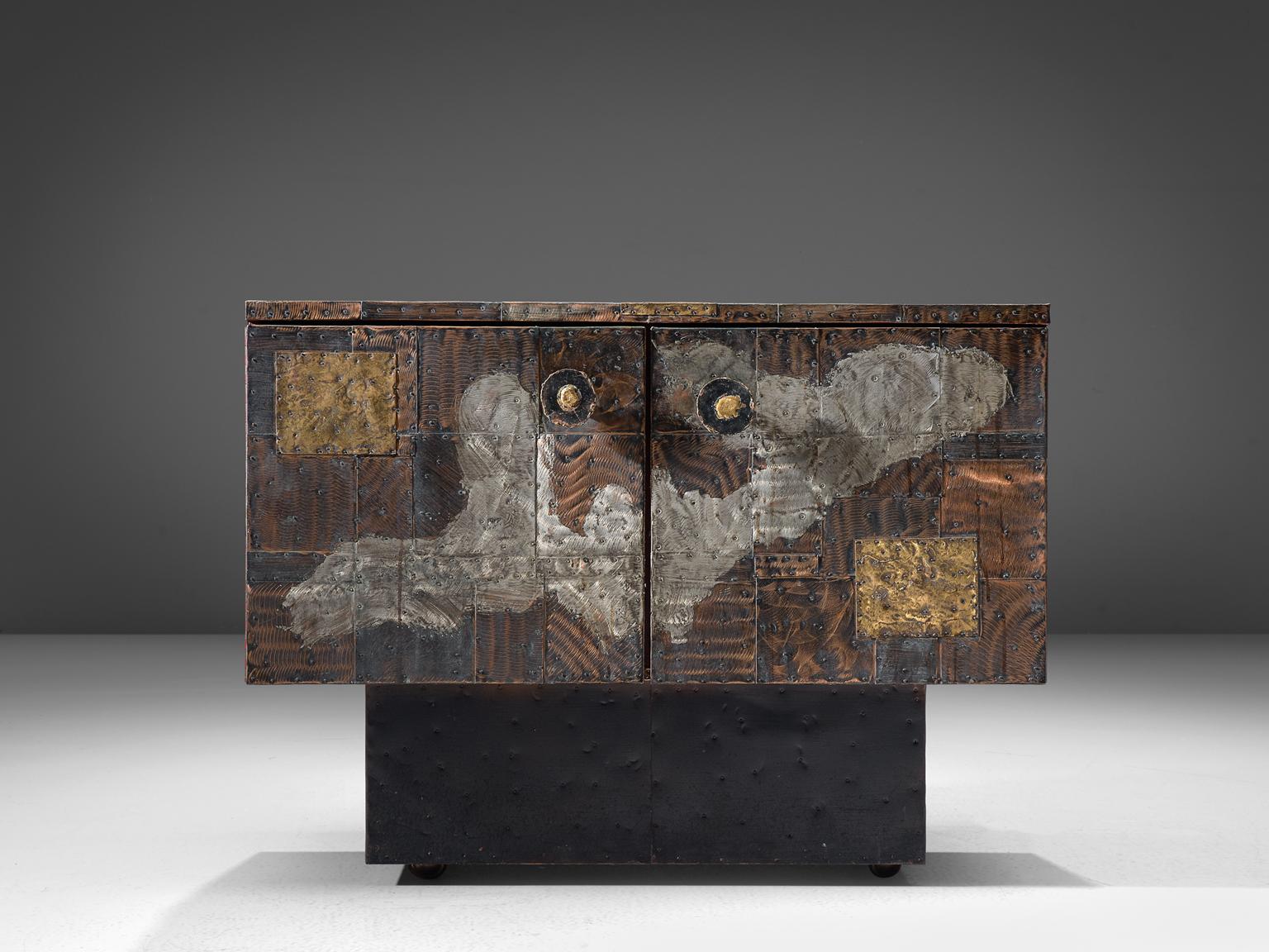 Paul Evans Studio for Directional, patchwork cabinet model PE-302, patinated copper, steel, brass, slate, United States, circa 1960.

Raw and robust small sideboard designed and produced by Paul Evans for Directional furniture. The wheeled sideboard