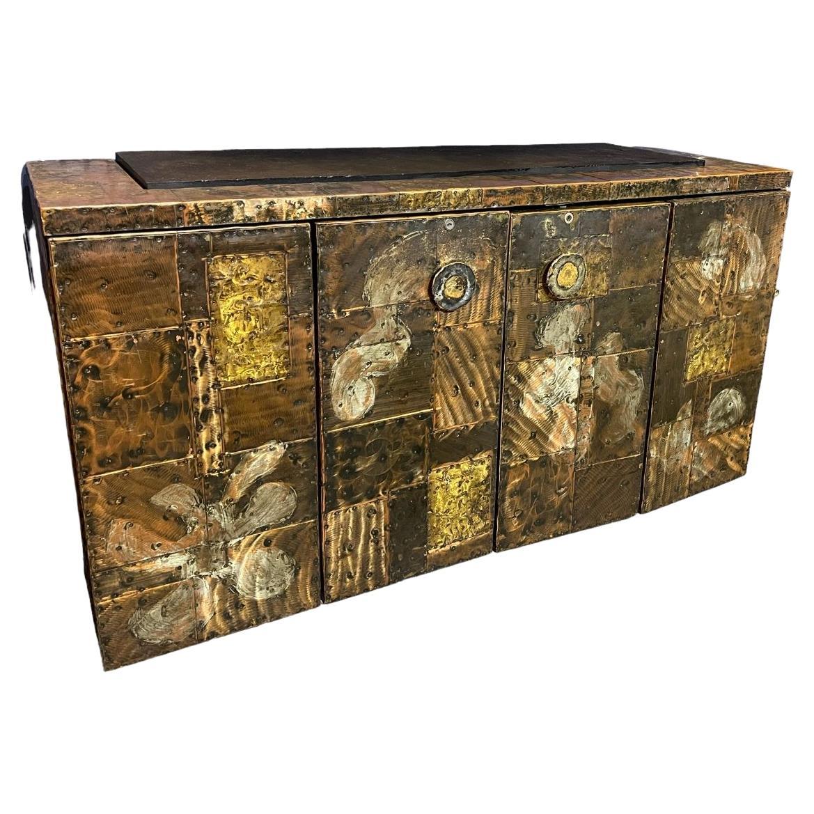  Stunning and rare copper clad wall mounted floating console/sideboard cabinet by Paul Evans for Directional, produced circa 1970. This incredible piece of design history is fabricated from patinized pieces of copper, brass, and pewter which have