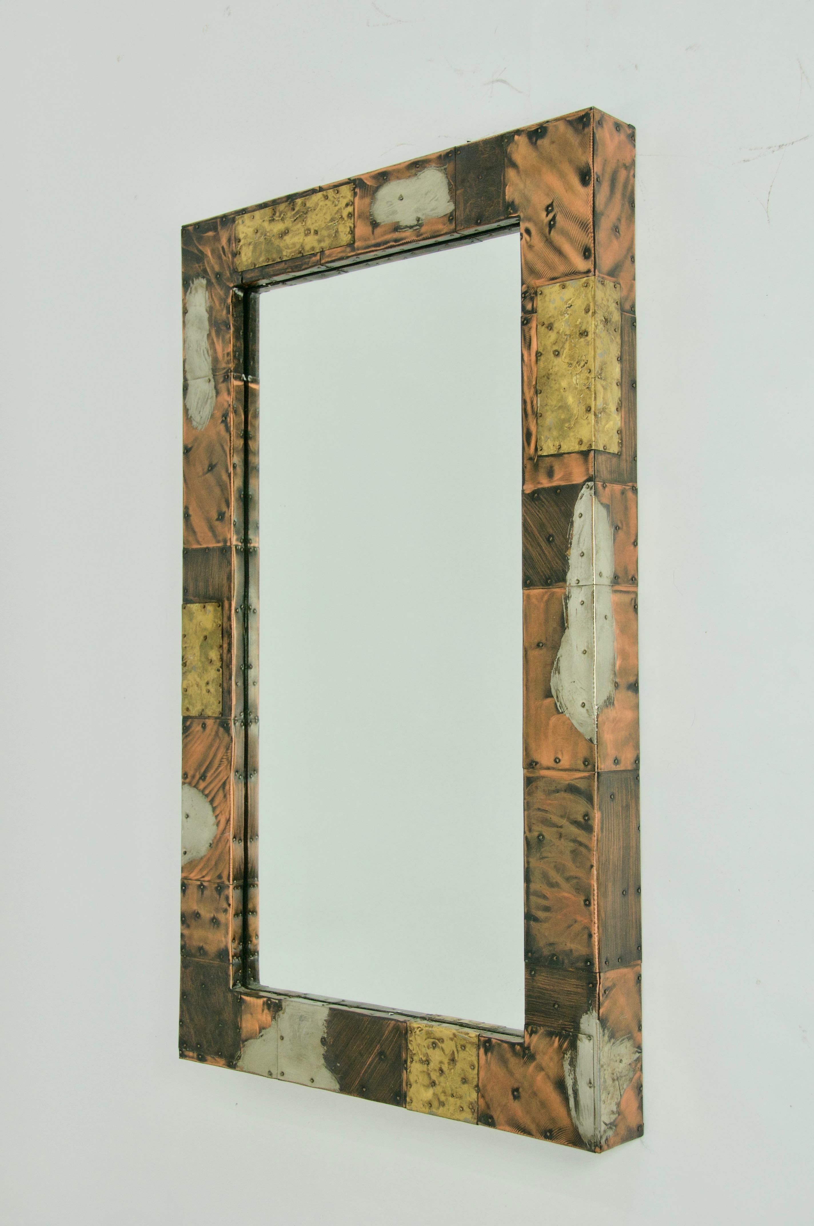 Paul Evans patchwork mirror made of pewter, copper, and brass.