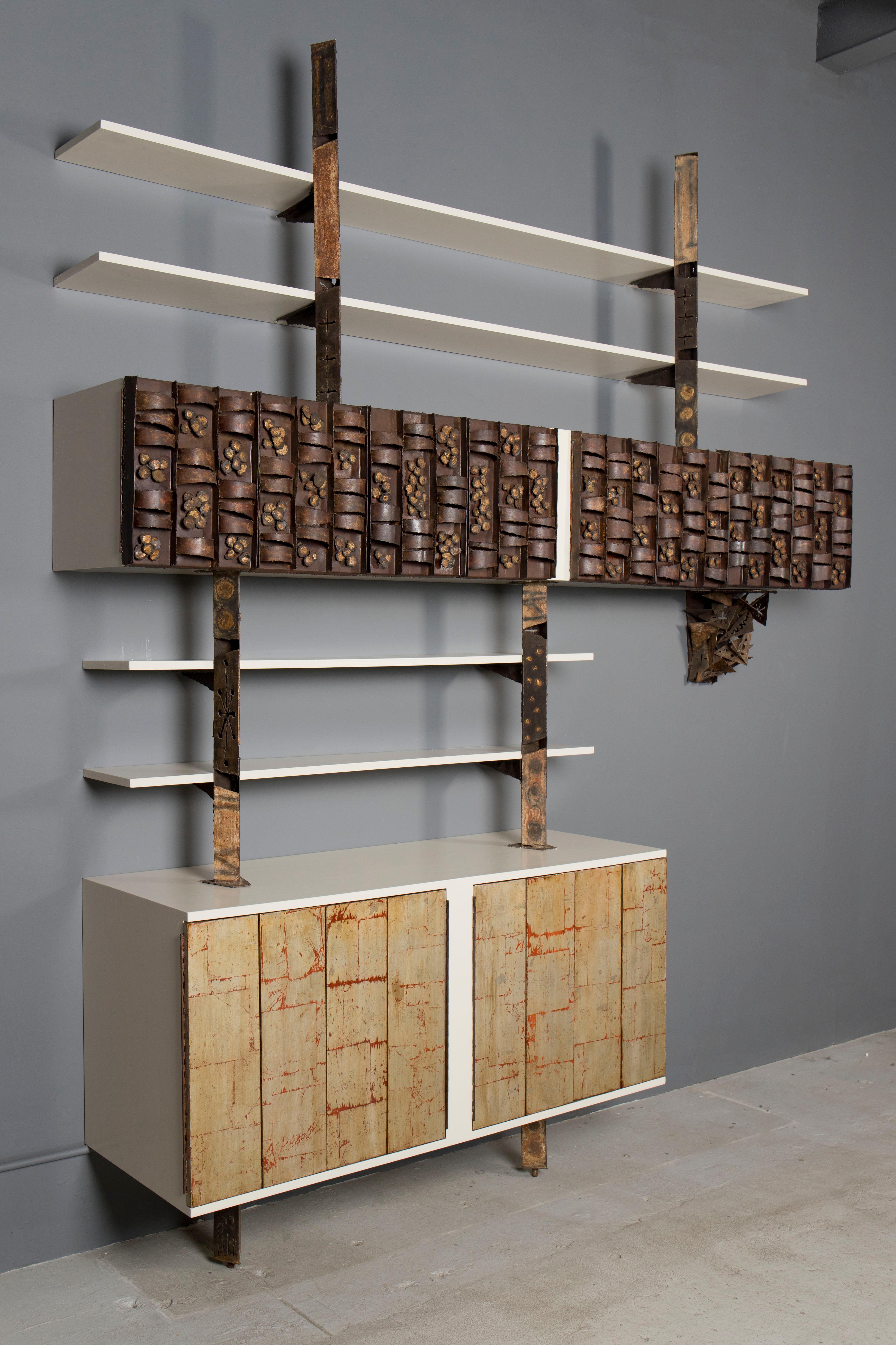 Unique wall - hung cabinet, collaboration between two great American studio artists - Paul Evans and Phillip Lloyd Powell.
Upper part showcases Evan's brutalist torch-cutting, welding and enameling technics, and the lower, Powell's wood gilding,