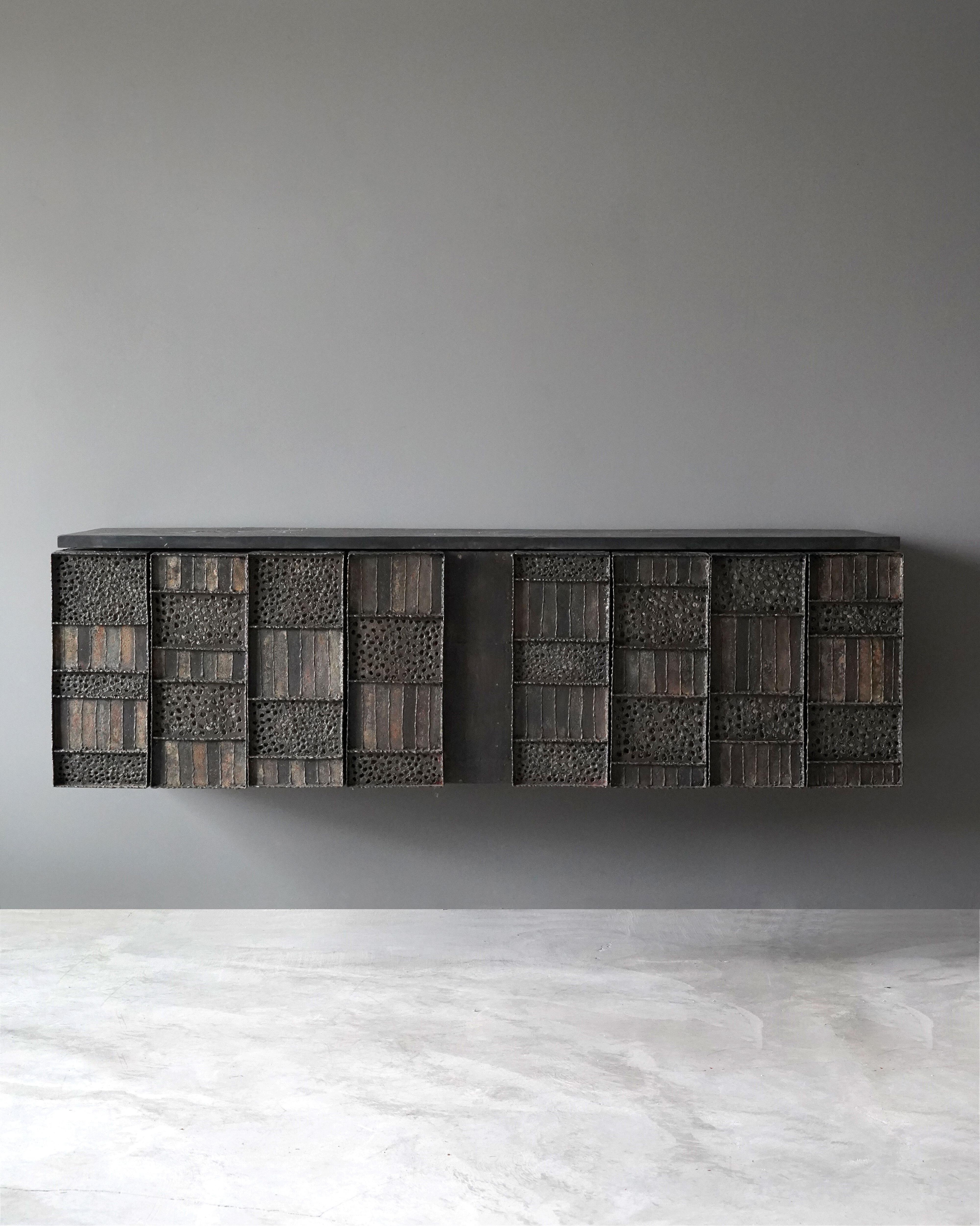 A rare wall-mounted cabinet. Designed and produced by Paul Evans in his studio, New Hope, Pennsylvania, America. Features welded, perforated, and hand-painted steel over wood, original slate top. 

Production of this model cabinet started in 1962