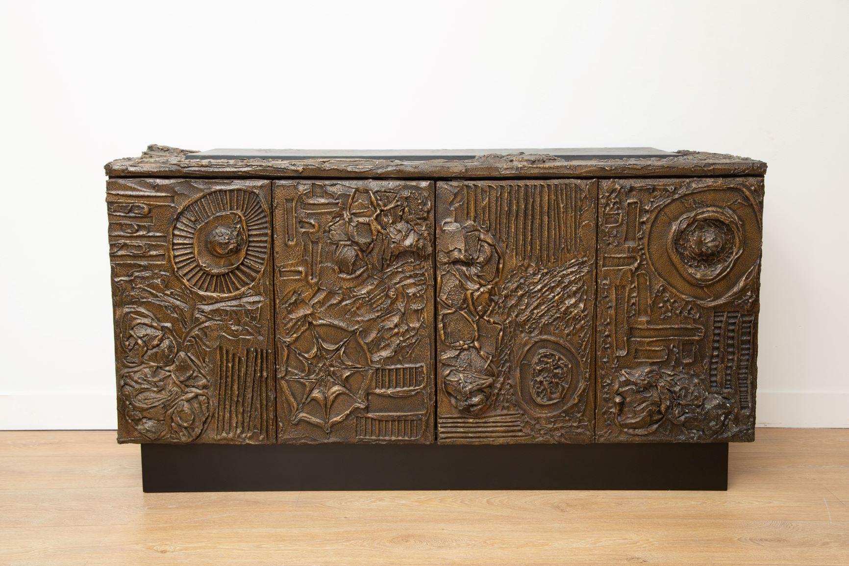 Paul Evans Brutalist sculpted bronze cabinet 
Sculpted-bronze series cabinet, 
Exceptional abstract forms, solid volumes and powerful brutal shapes,
Two bi-fold doors concealing storage with adjustable shelves to each side.
One large inset slate