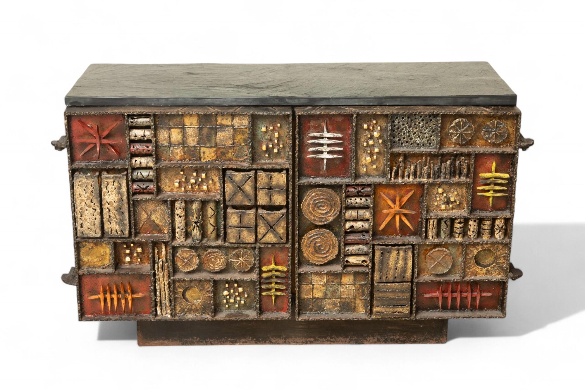 Paul Evans, Sculpture Front cabinet, USA 1969
Rare forged sculpture front tow-door cabinet.
Gilt, painted & welded and patinated steel, hand-cleft slate top, yellow lacquer interior with four adjustable shelves
This series is considered to be the