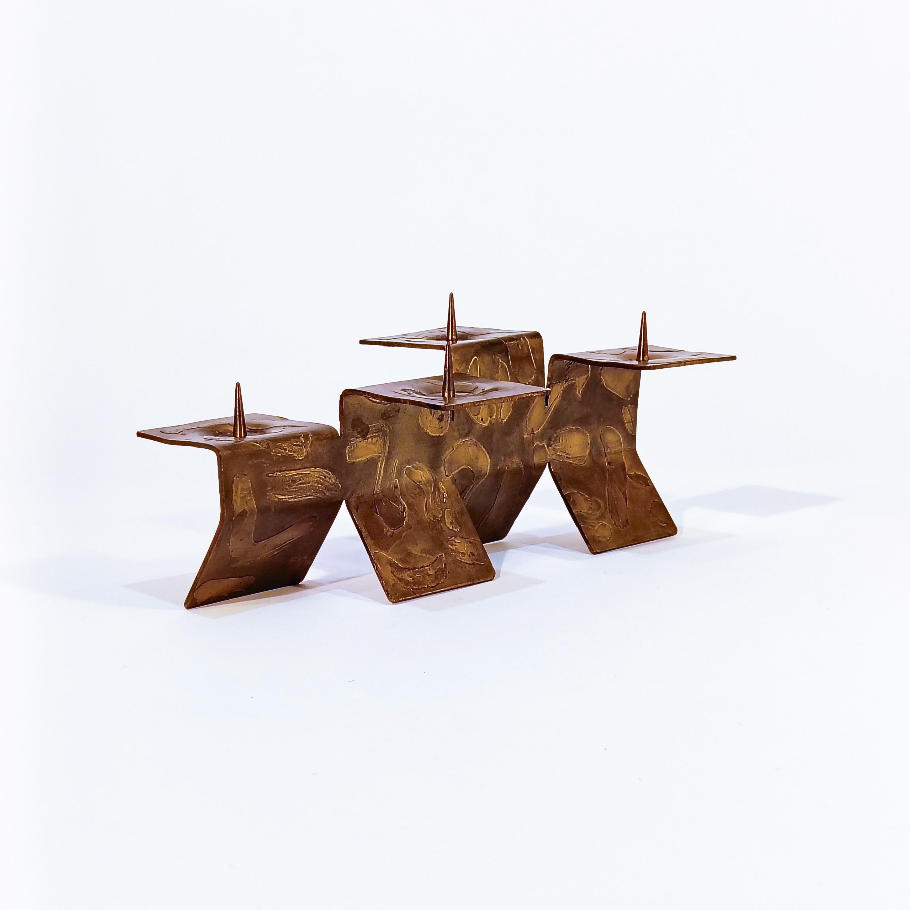 Brutalist candelabra in the style of Paul Evans, 1960s. Frmed by a thick sheet of bronze bent on several sides forming 4 candle holders. Textured surface, with varnished finish. Possibly of Italian origin. Very much in the style of the creations of