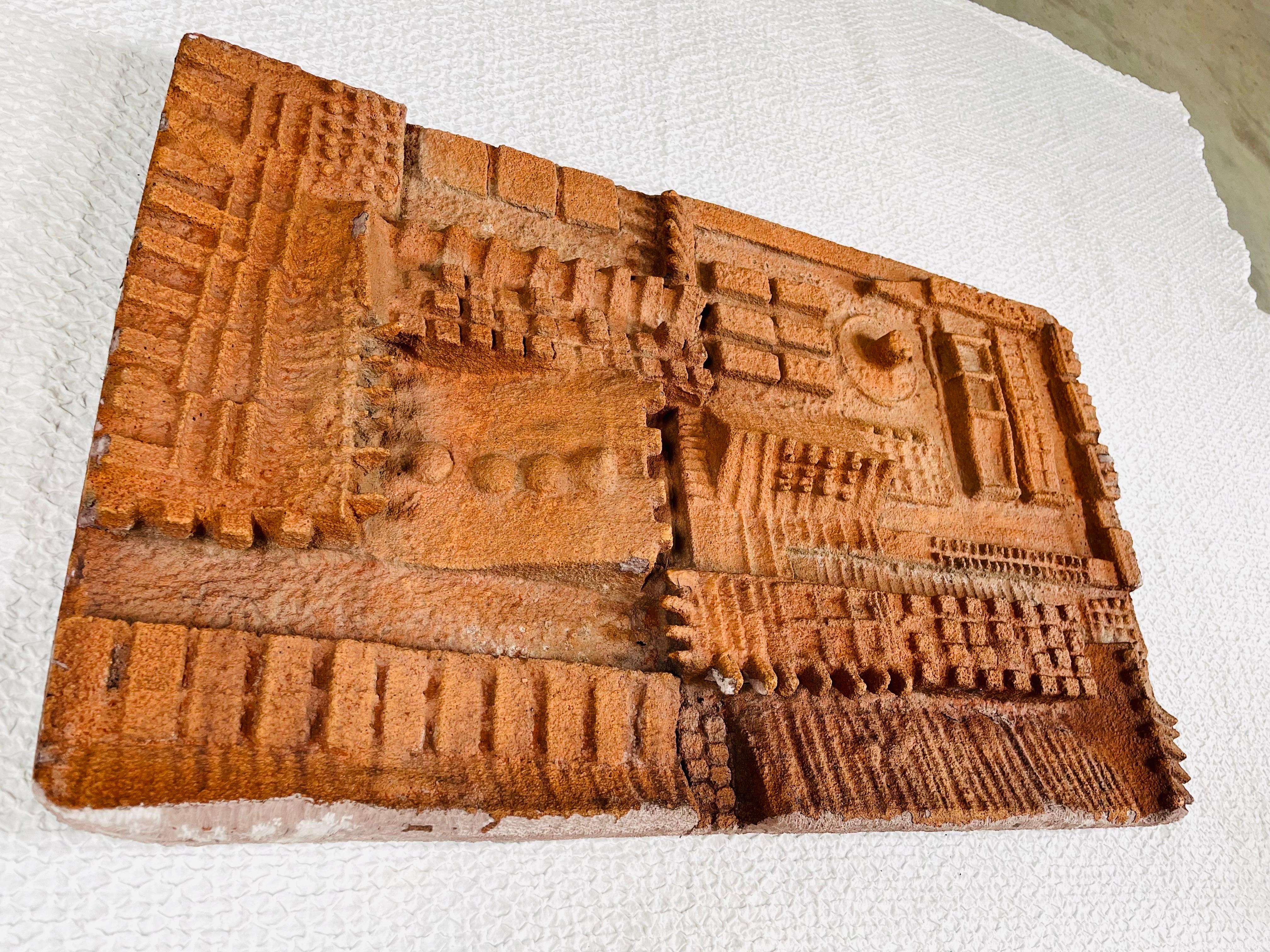 A stunning 3 dimensional brutalist wall sculpture in molded terracotta having unique abstract features throughout. Likely molded over a carved piece of wood and supported with a mesh of fiberglass. Strong condition having some minor spots of flaking