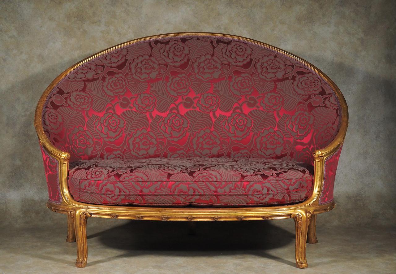 Frühklassische französische Art-Déco-Sitzgruppe aus geschnitztem Goldholz. Die Sitzgruppe besteht aus einer Couch, zwei Sesseln, zwei Beistellstühlen und einem kleinen Tisch. Die Chaiselongue aus dieser Suite befindet sich in der Sammlung der