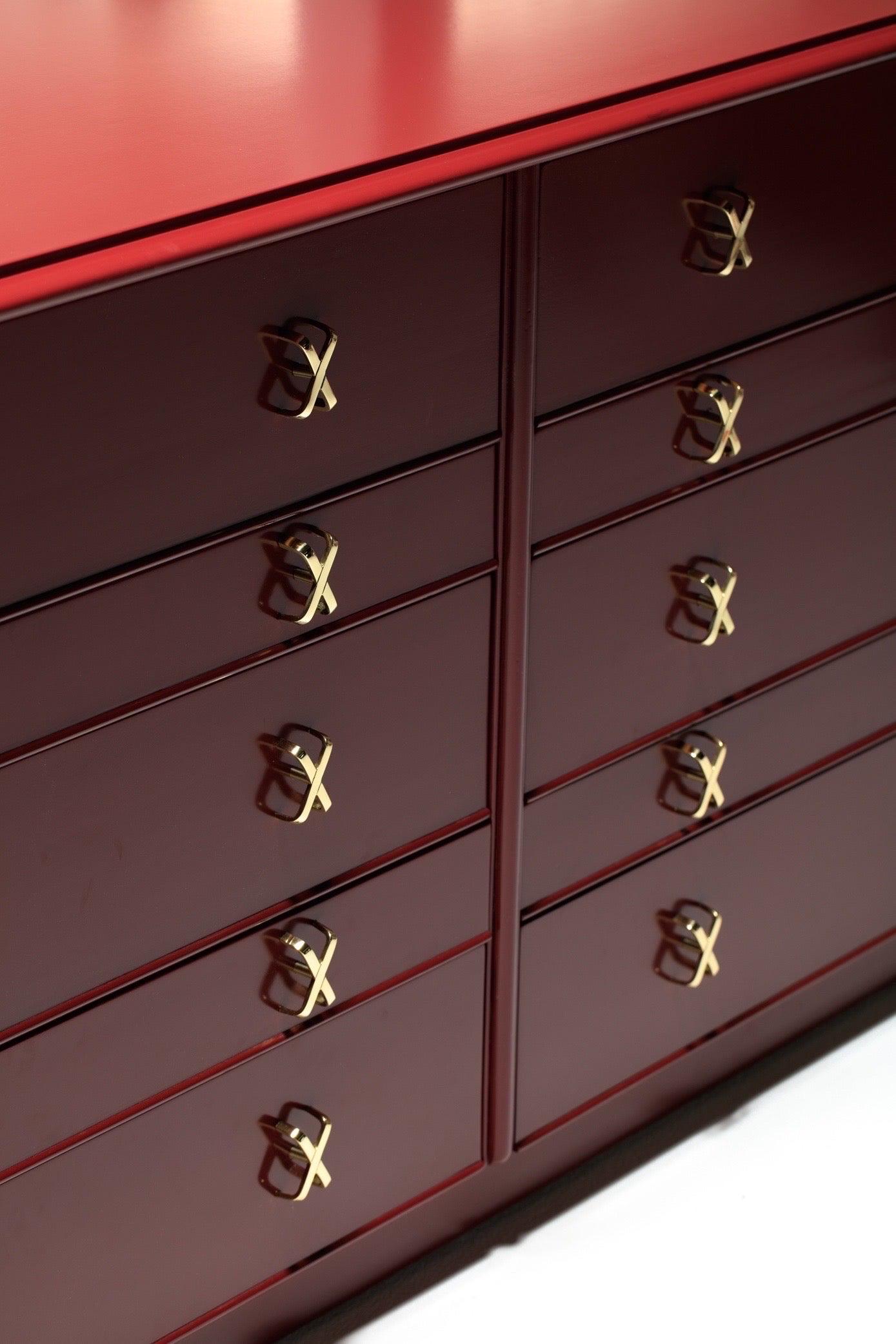 Iconica cassettiera a 10 cassetti di Paul Frankl con tiretti a X in ottone appena lucidato, rifinita e mostrata in lacca rosso pomodoro essiccato al sole della Collection'S Debonair di Frankl per Johnson Furniture. Coppia disponibile. Si prega di