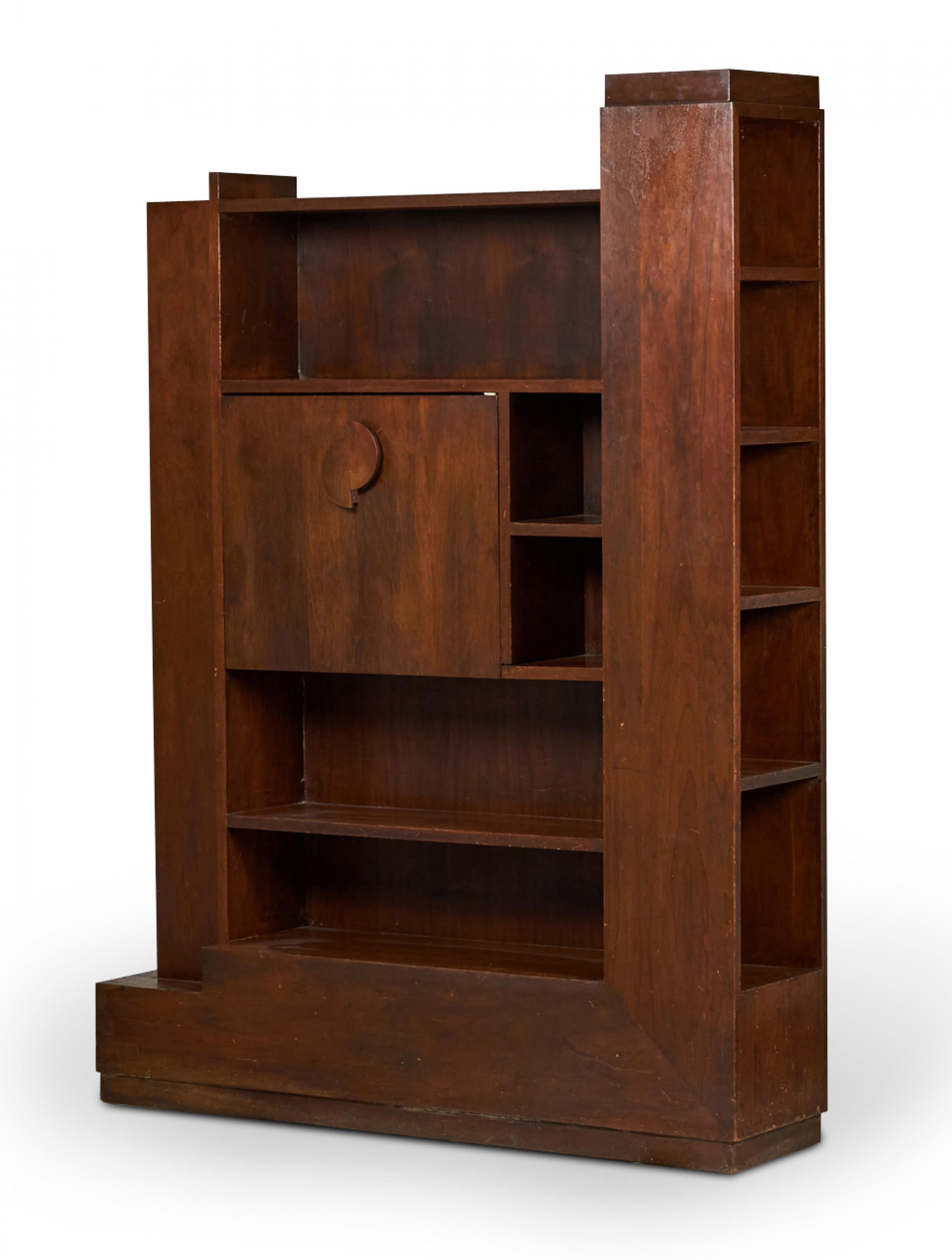 American Mid-Century walnut fall-front skyscraper desk with a main multi-shelved cabinet flanked on either side by additional shelving units with a central panel that falls forward to create a desktop. (PAUL FRANKL)

Condition: Good; Wear consistent
