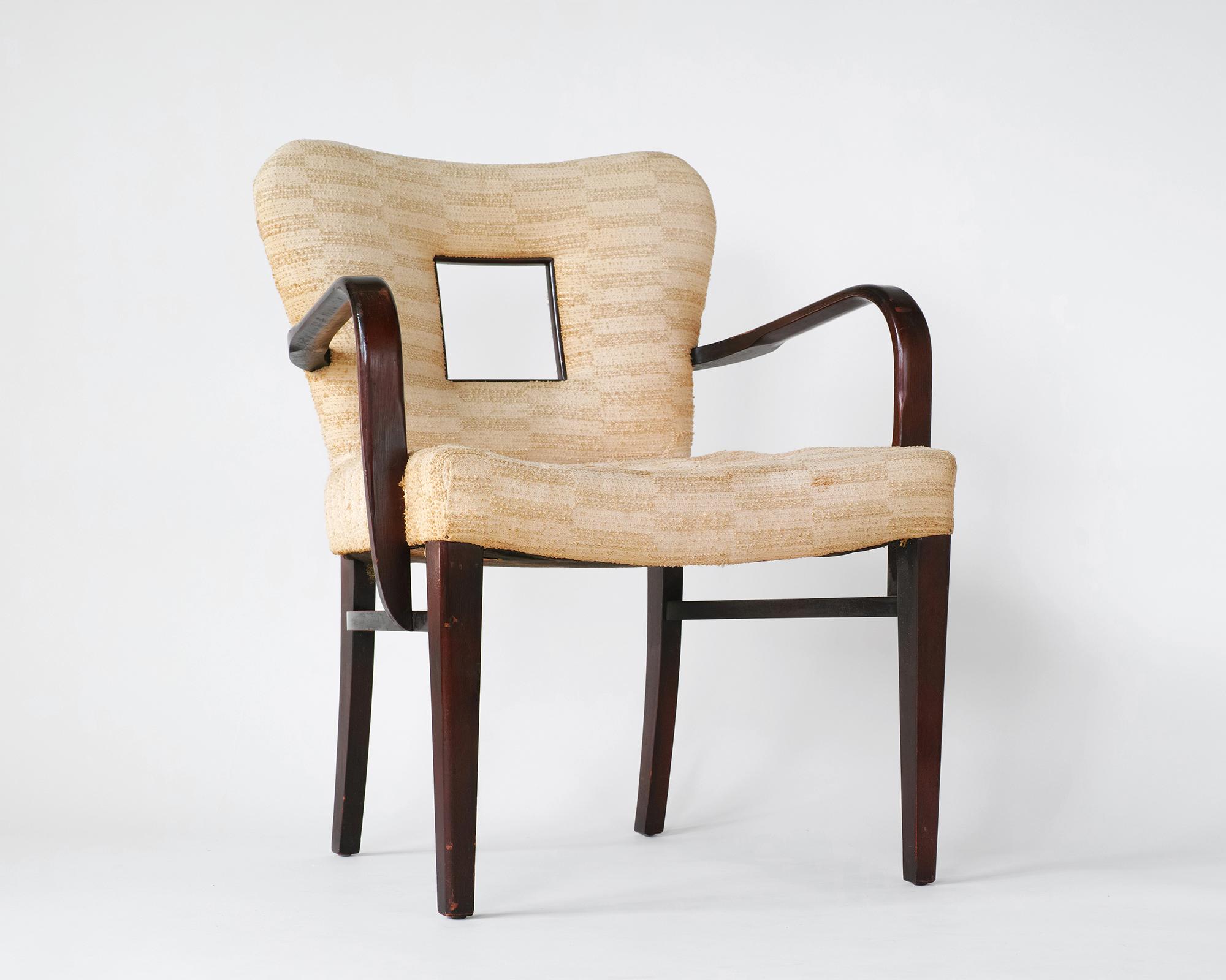 For your consideration is this rare model 2254 ½ armchair designed by Paul Frankl in all-original, unrestored condition. It features a sculptural solid wood frame with delicate curves and a distinctive window cutout in the backrest. The arm height