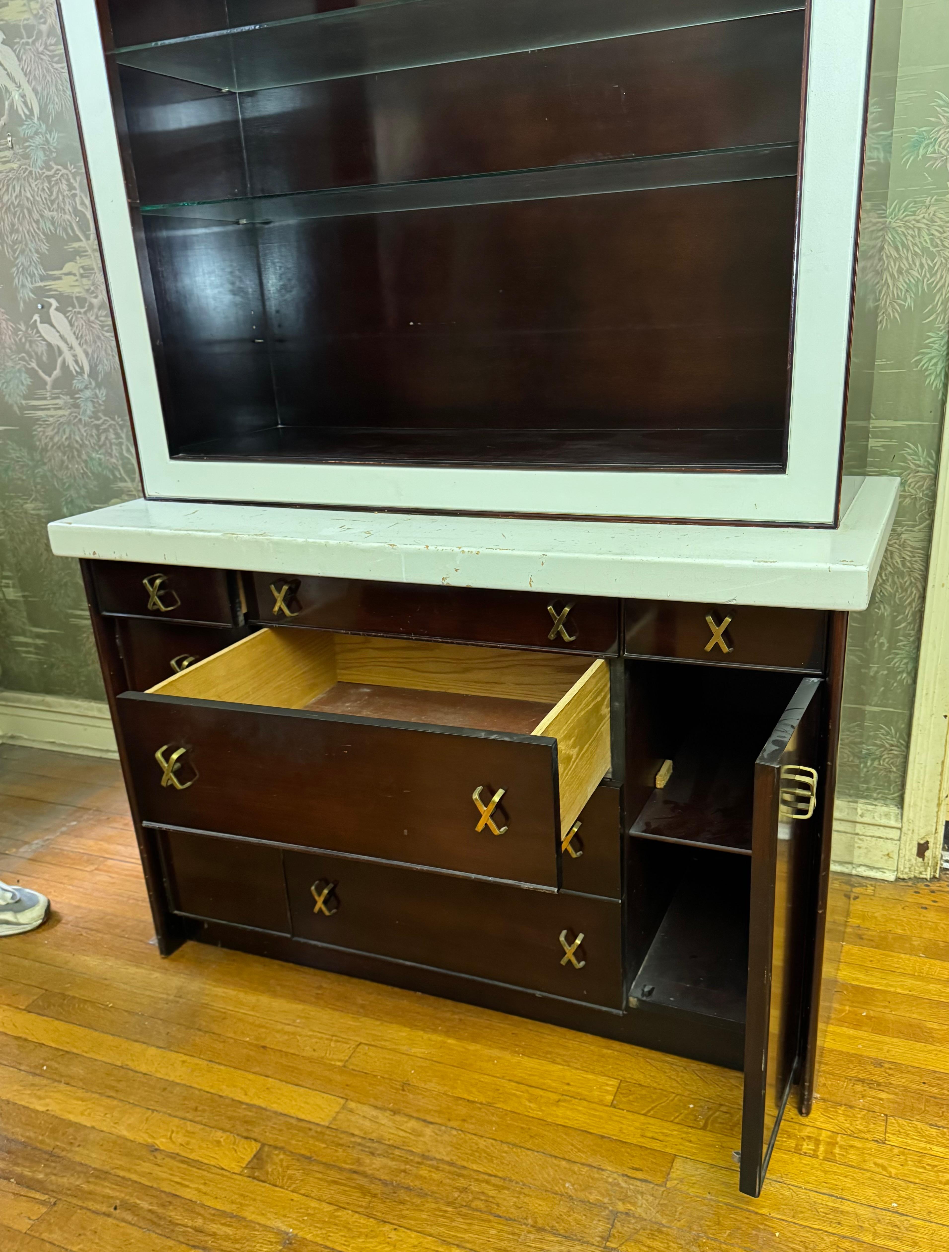 Uno splendido mobile in mogano tinto scuro, ottone e sughero, disegnato da Paul Frankl e prodotto da Johnson Furniture Company, Grand Rapids, Michigan, USA, anni '50 circa. Mantiene le condizioni e le finiture originali. Nel complesso presenta delle